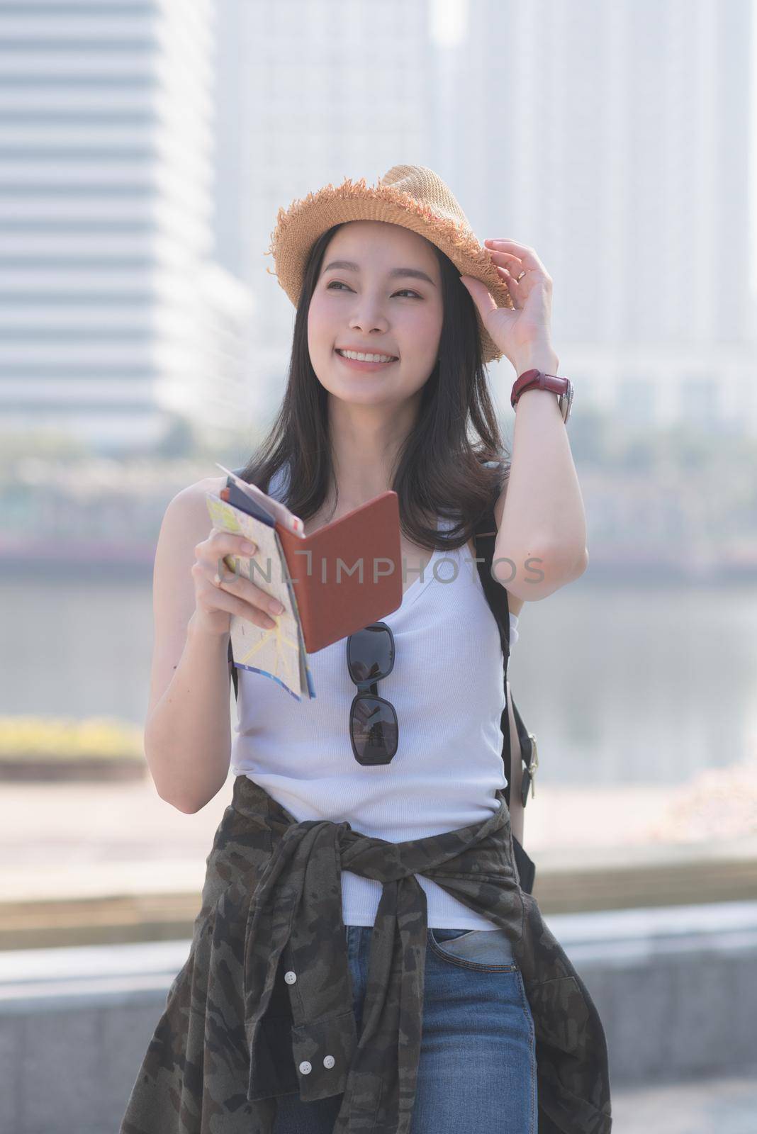 Beautiful asian solo tourist woman  smiling and searching for tourists sightseeing spot by Nuamfolio