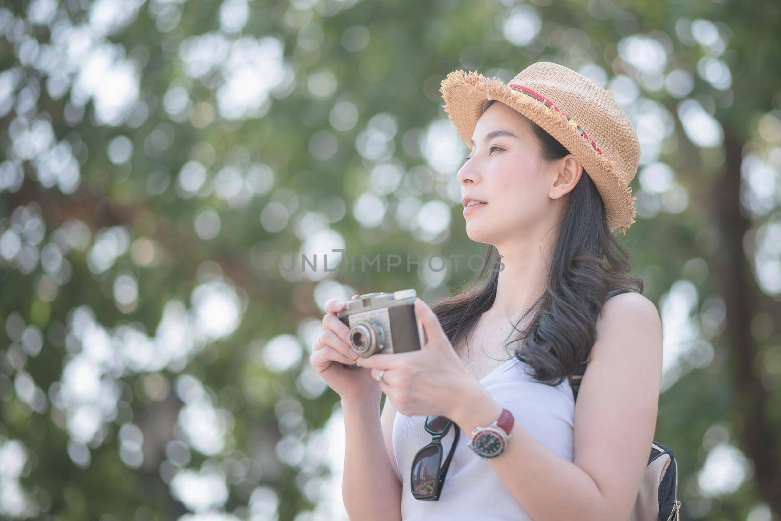 Beautiful asian solo tourist woman enjoy taking photo by retro camera at tourist sightseeing spot by Nuamfolio