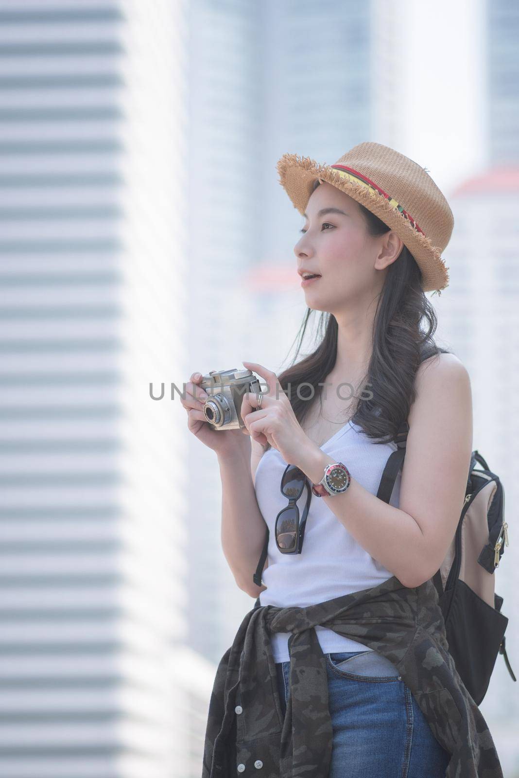 Beautiful asian solo tourist woman enjoy taking photo by retro camera at tourist sightseeing spot. by Nuamfolio