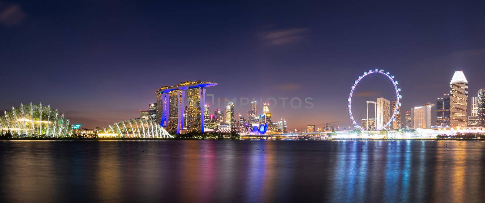 Panorama view of downtown business buildings area at night in Singapore.Singapore is a world famous tourist city. by Nuamfolio