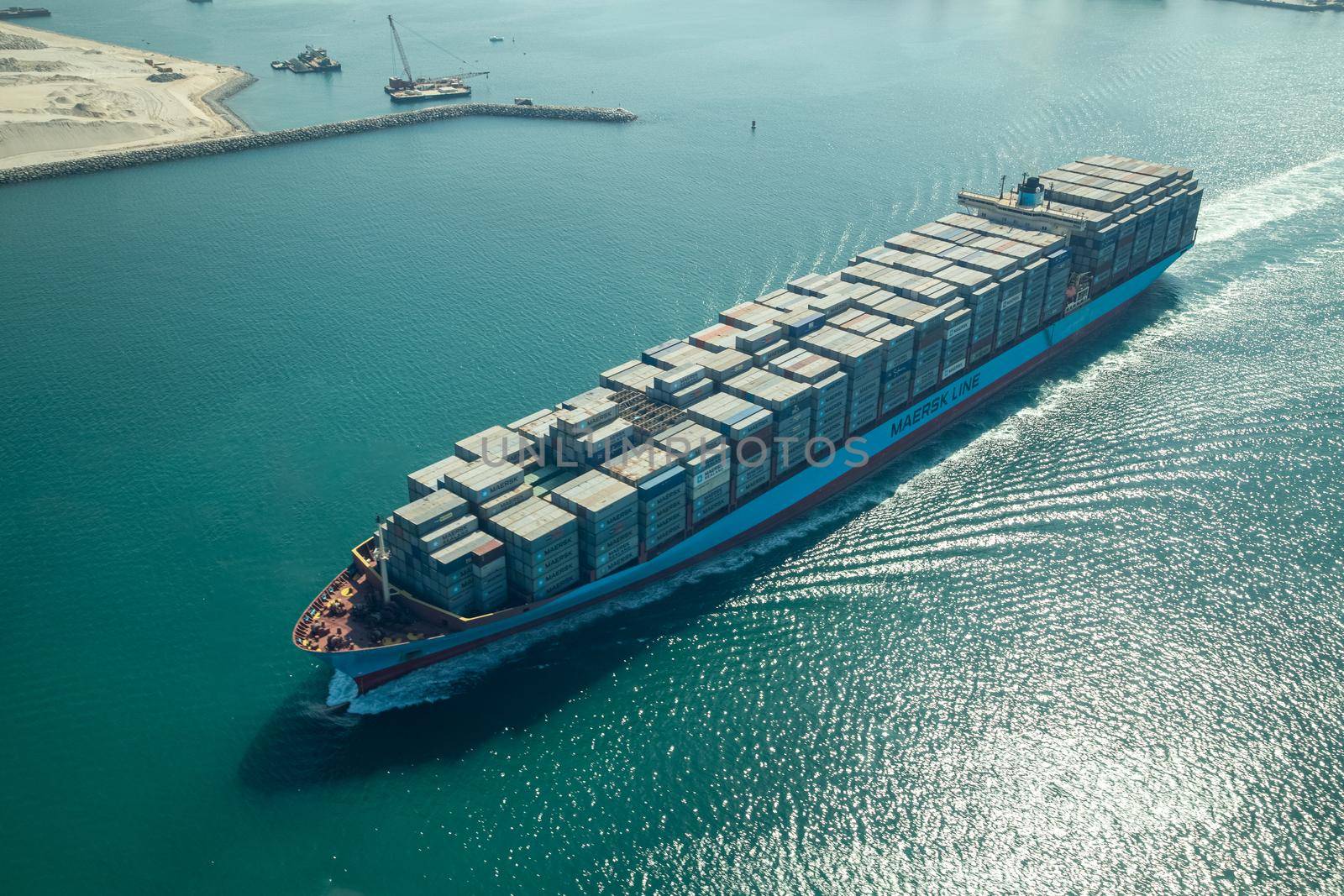 Dubai, United Arab Emirates - October 17, 2014: Aerial view of a cargo container ship leaving the harbor