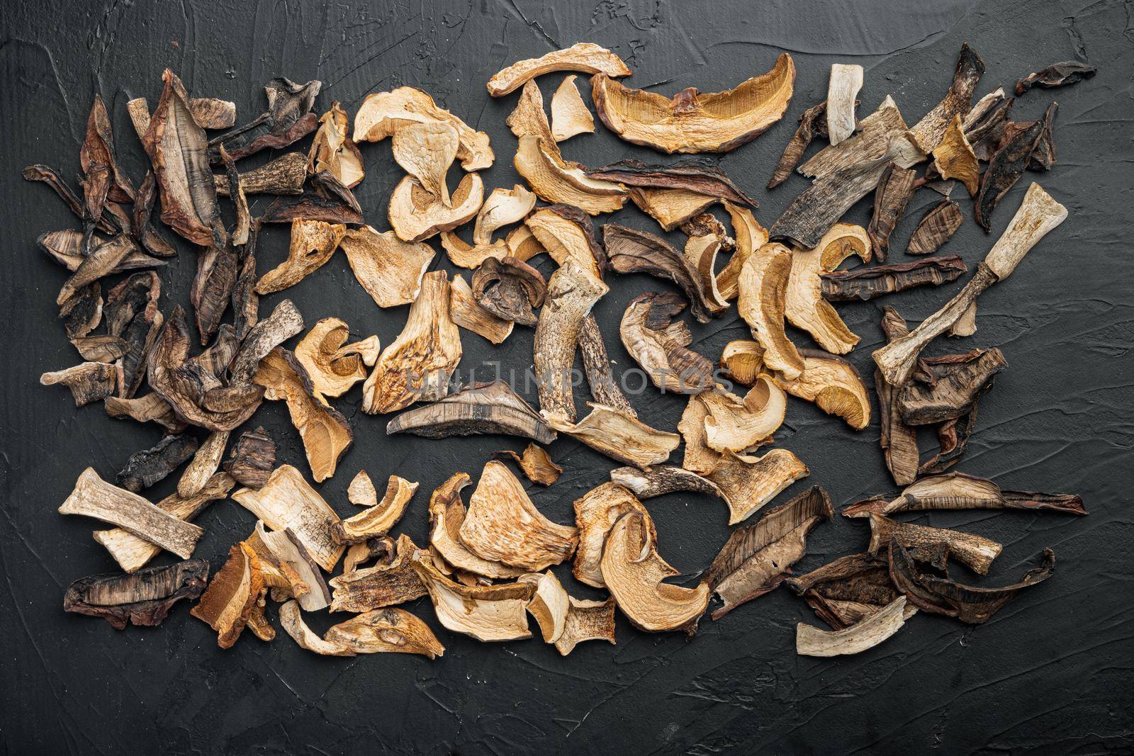 Dried mushrooms set, on black background, top view flat lay