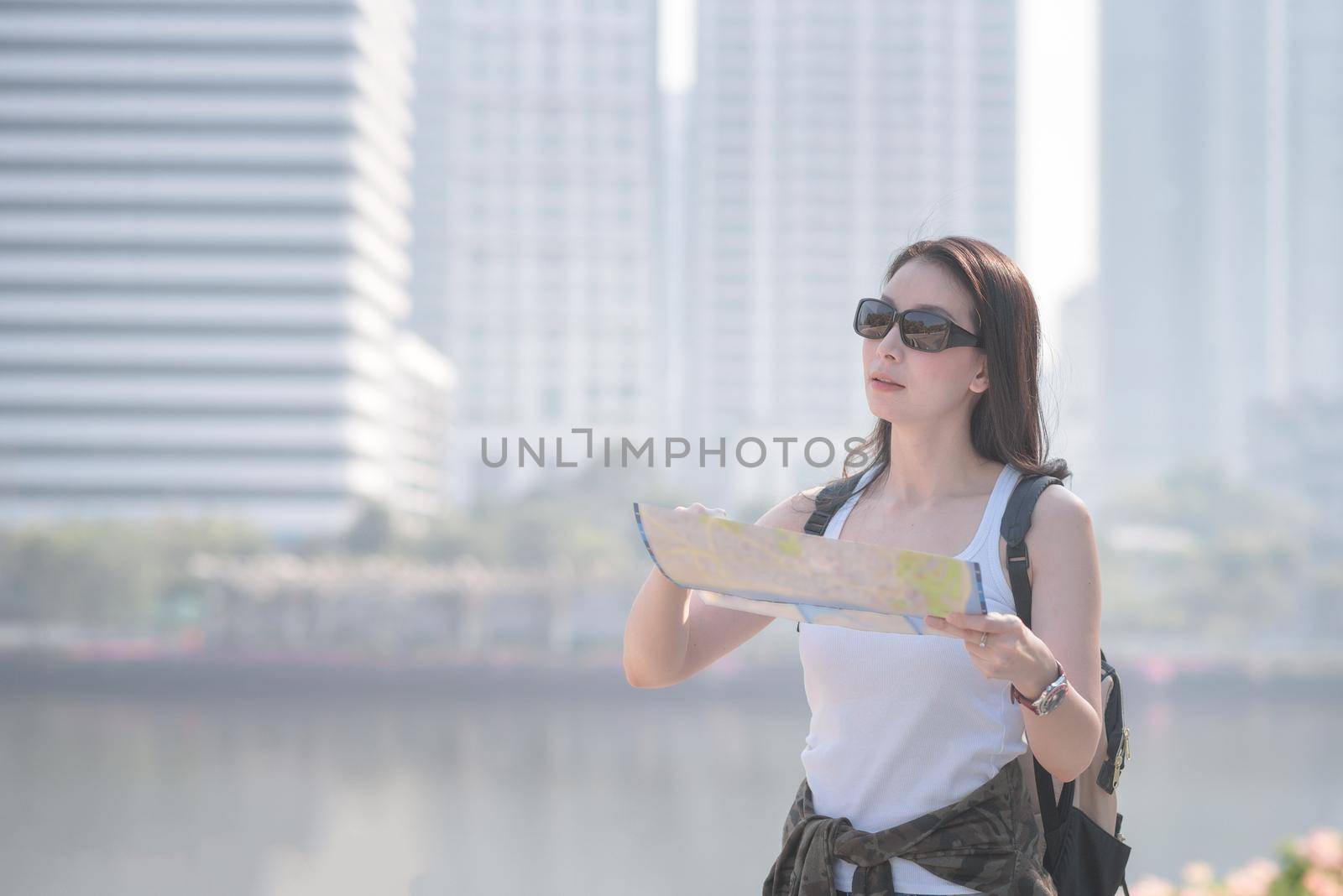 Beautiful asian solo tourist woman  looking at the map searching for tourists sightseeing spot by Nuamfolio