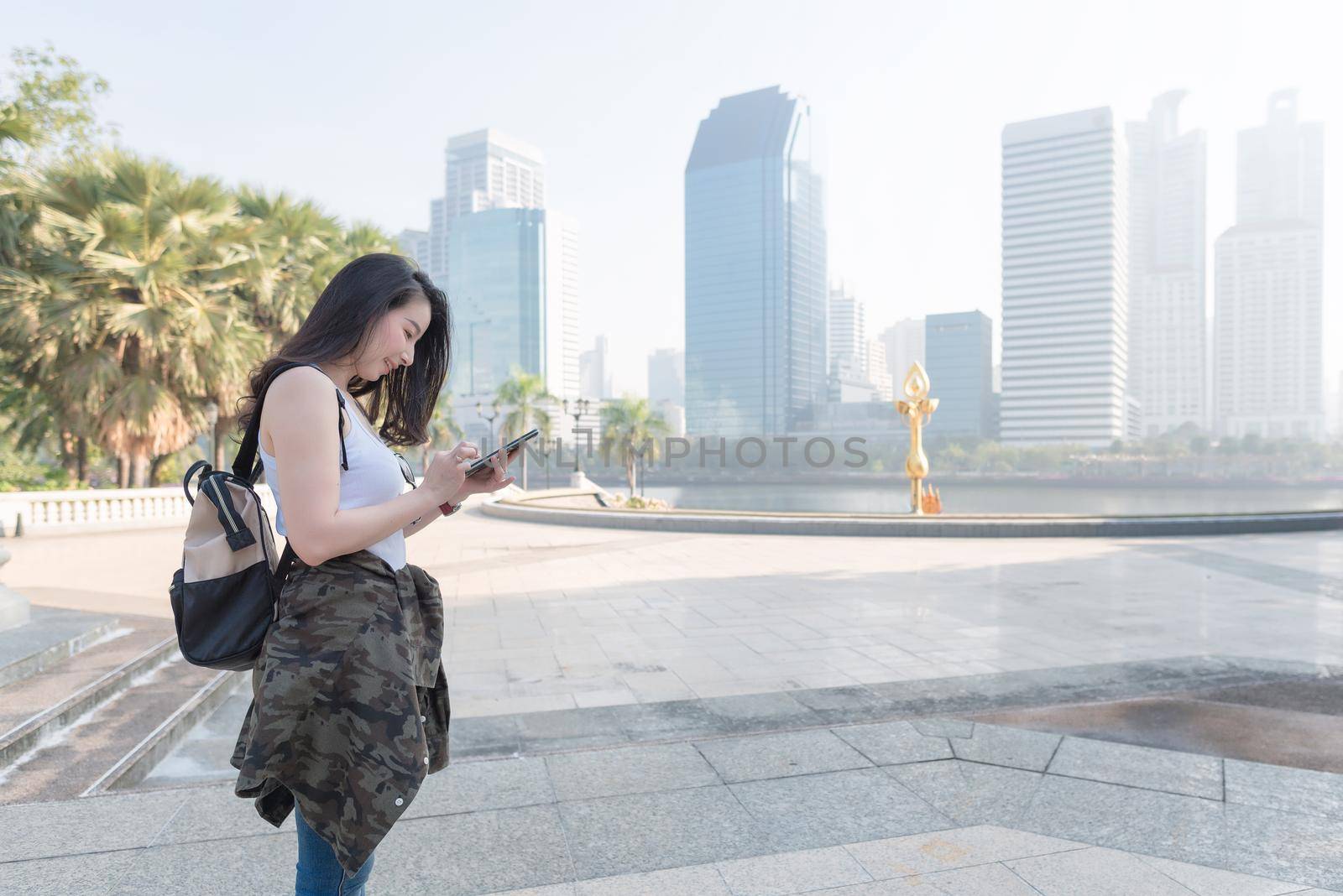 Beautiful asian tourist woman looking at mobile phone for searching location of landmark by Nuamfolio