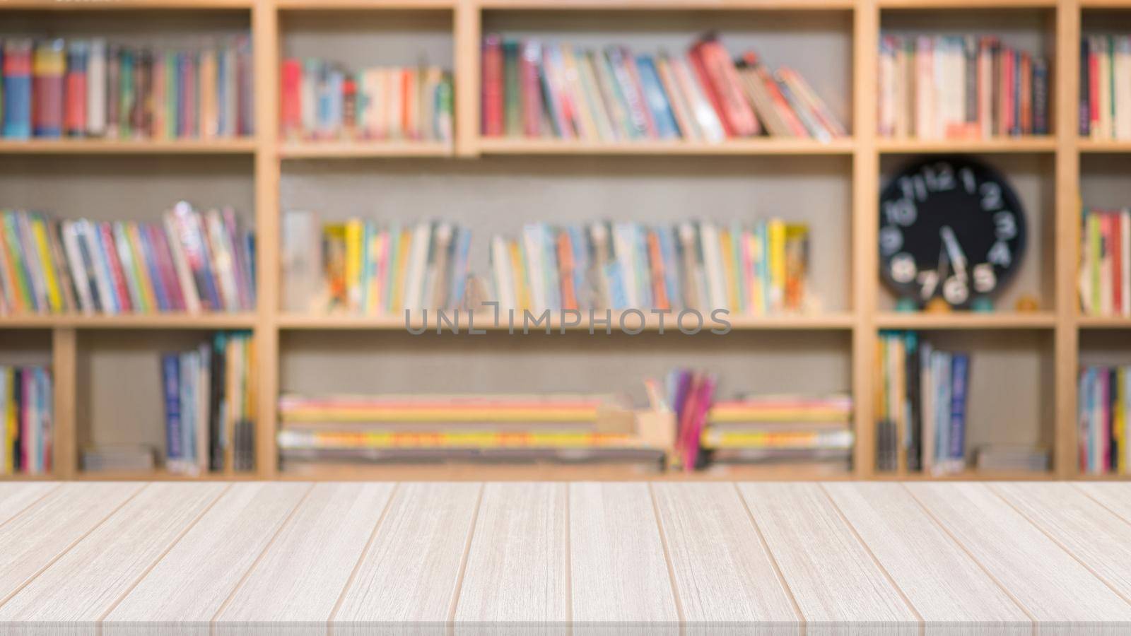 Wooden table in the library with a blurred bookshelf with many book in the background by Nuamfolio