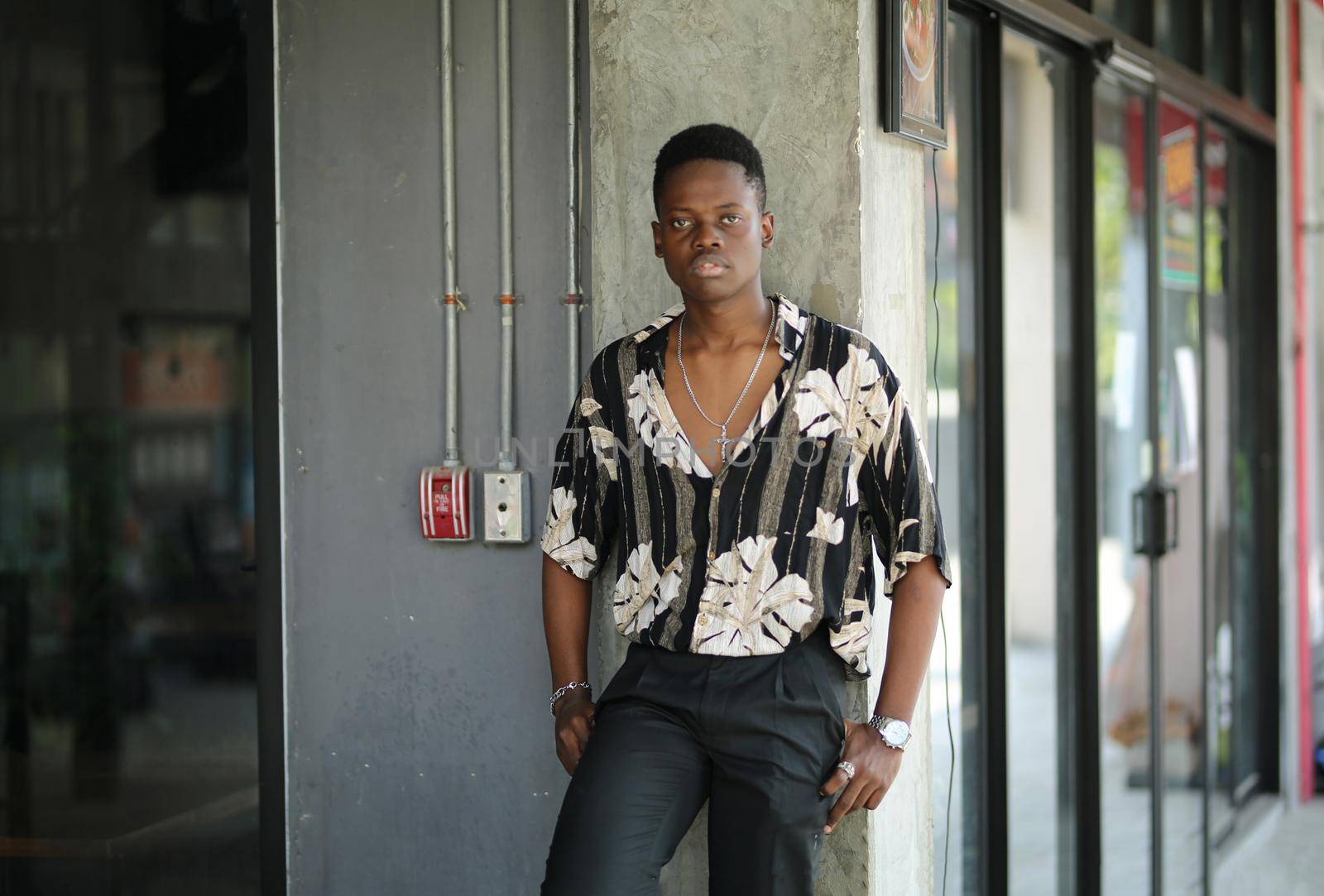 Portrait of young handsome afro black man posing outdoor.