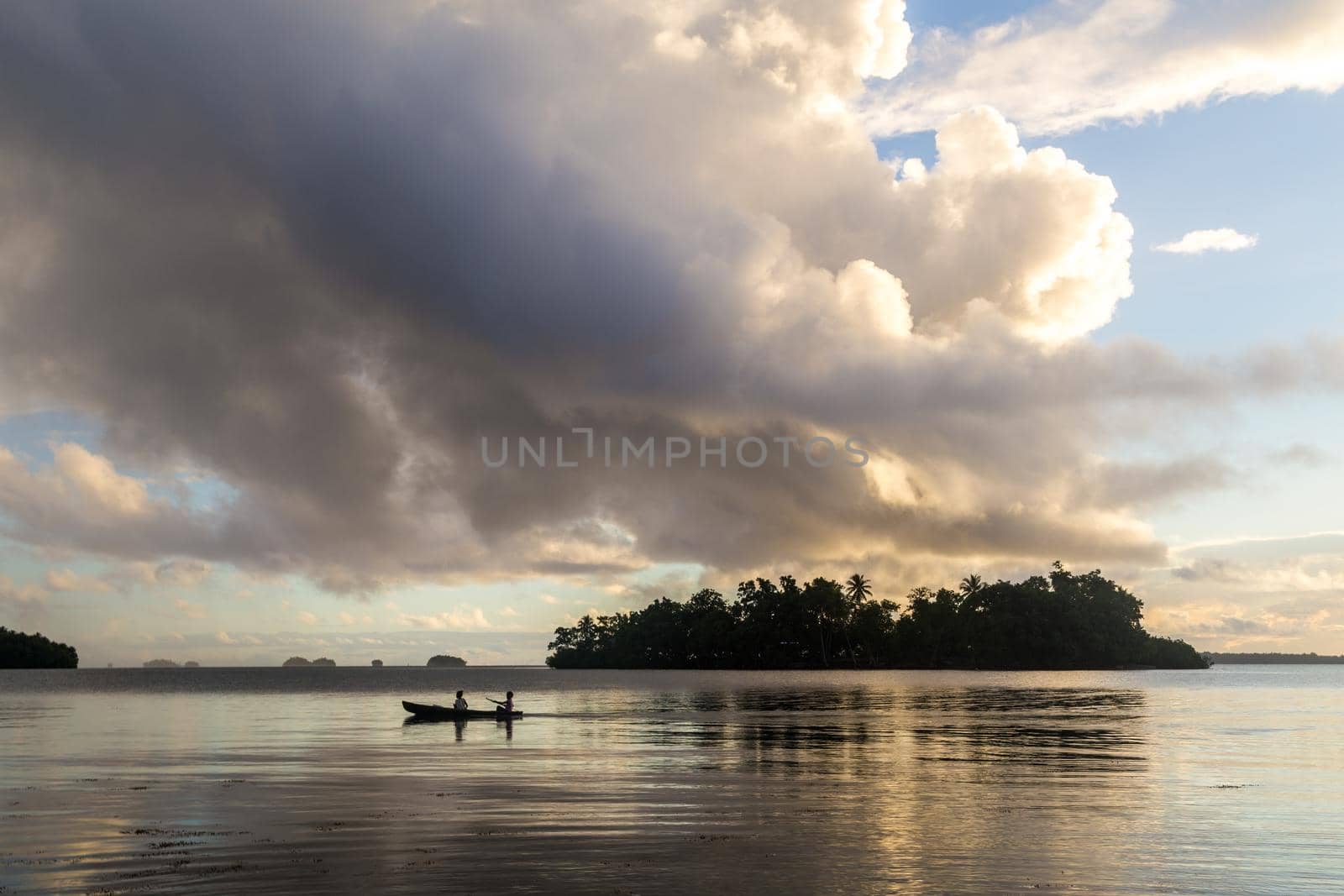 Marovo Lagoon, Solomon Islands - June 5, 2015: Children on the way to school with a canoe during sunrise