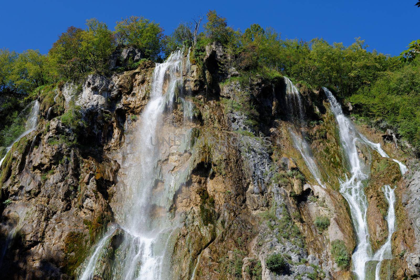 Waterfall in Plitvice, Croatia in bright summer day by slavapolo