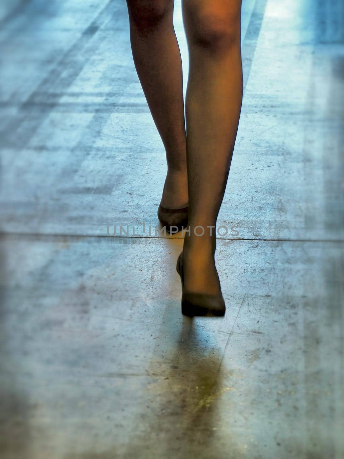 Close up of female legs steps wearing high heels elegant shoes on concrete floor