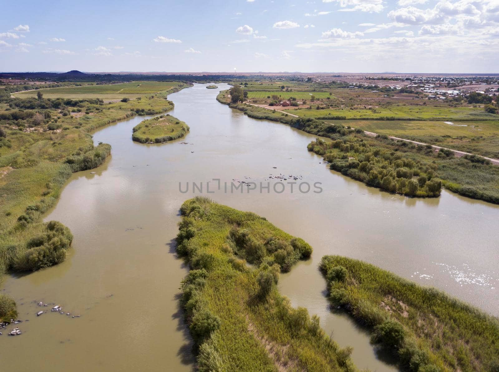 Large river flowing through farmlands in a flat landscape
