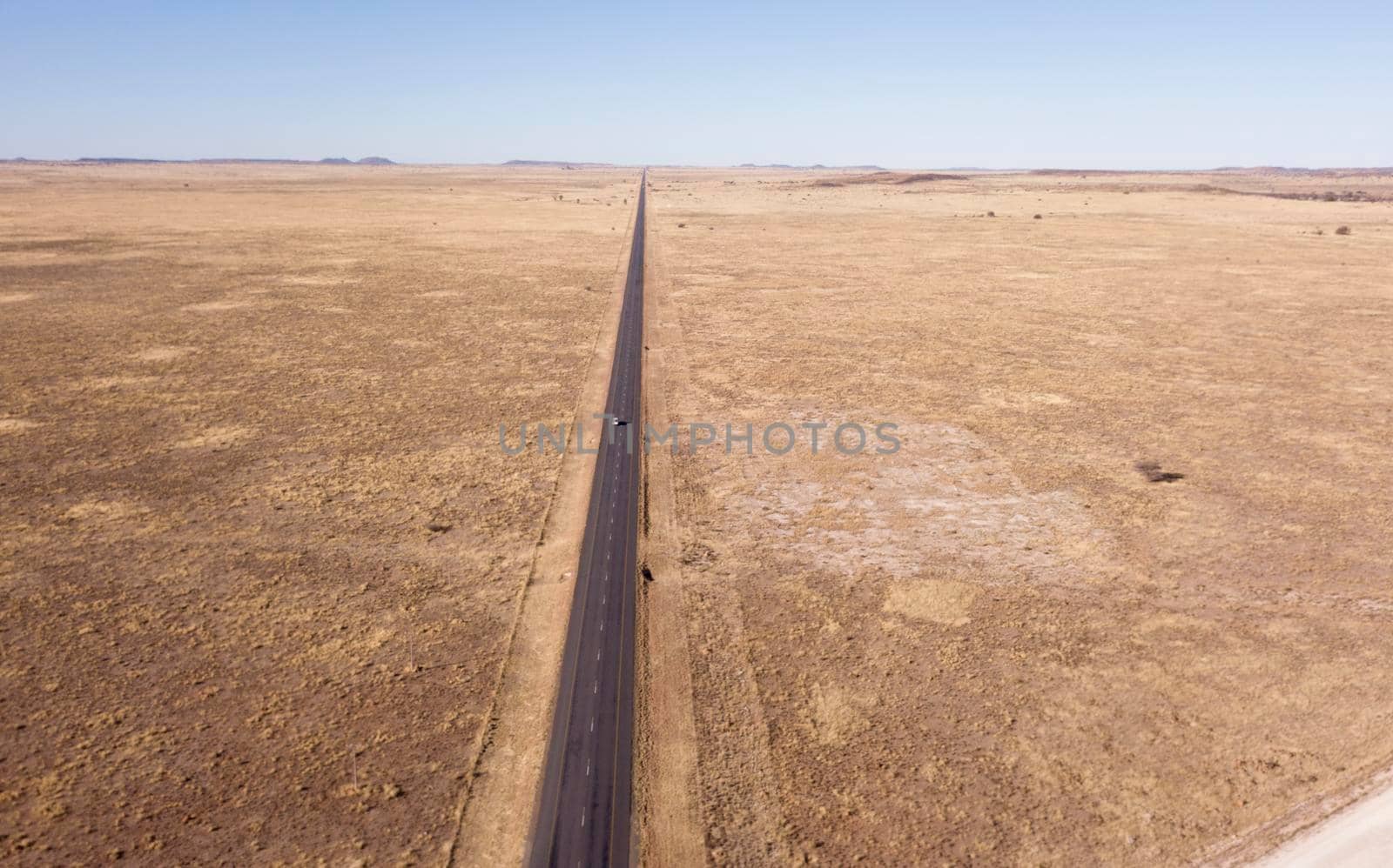 Aerial of long straight road in flat landscape