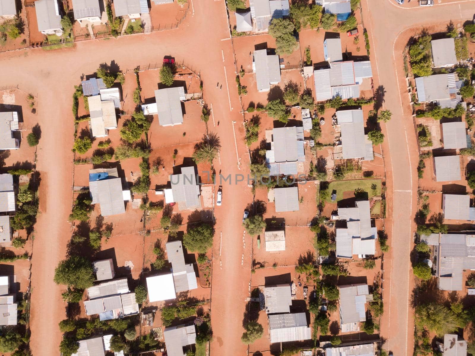 Aerial view above houses and dirt road streets in African village by fivepointsix