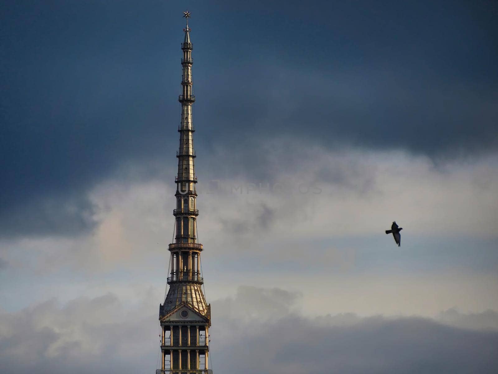 Scenic view of the spire of one of the city symbols, the mole antonelliana, from piazza castello under cloudy stormy sky Turin Italy October 10 2020 by lemar