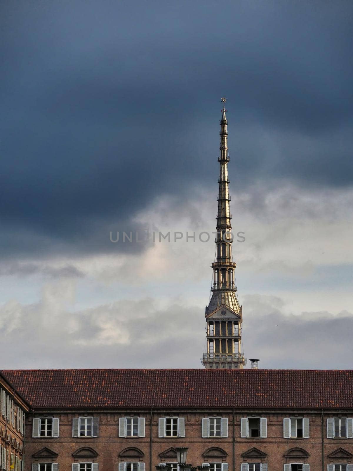 Scenic view of the spire of one of the city symbols, the mole antonelliana, from piazza castello under cloudy stormy sky Turin Italy October 10 2020