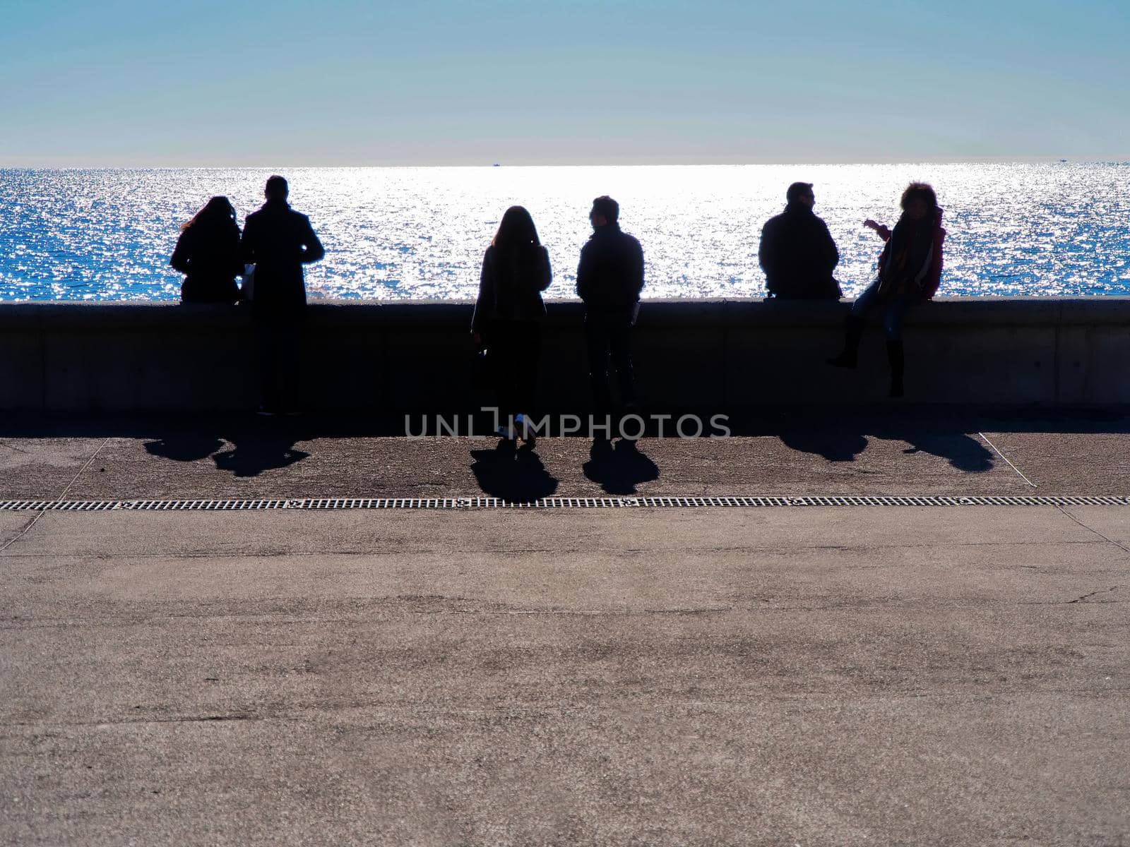 Tourists couples silhouette on waterfront