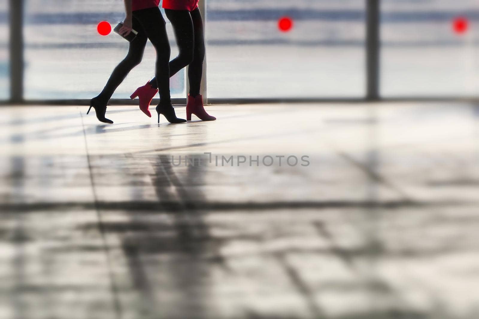 Close up legs of two women walking silhouette in blurry background