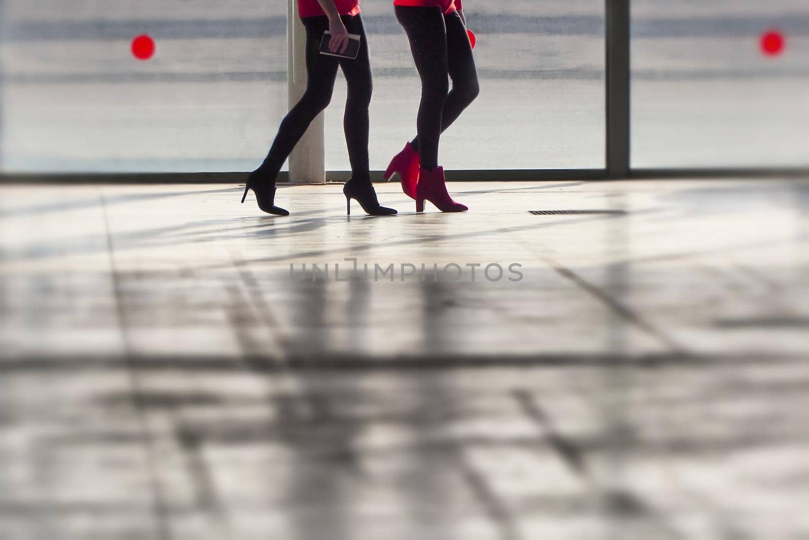 Close up legs of two women walking silhouette in blurry background