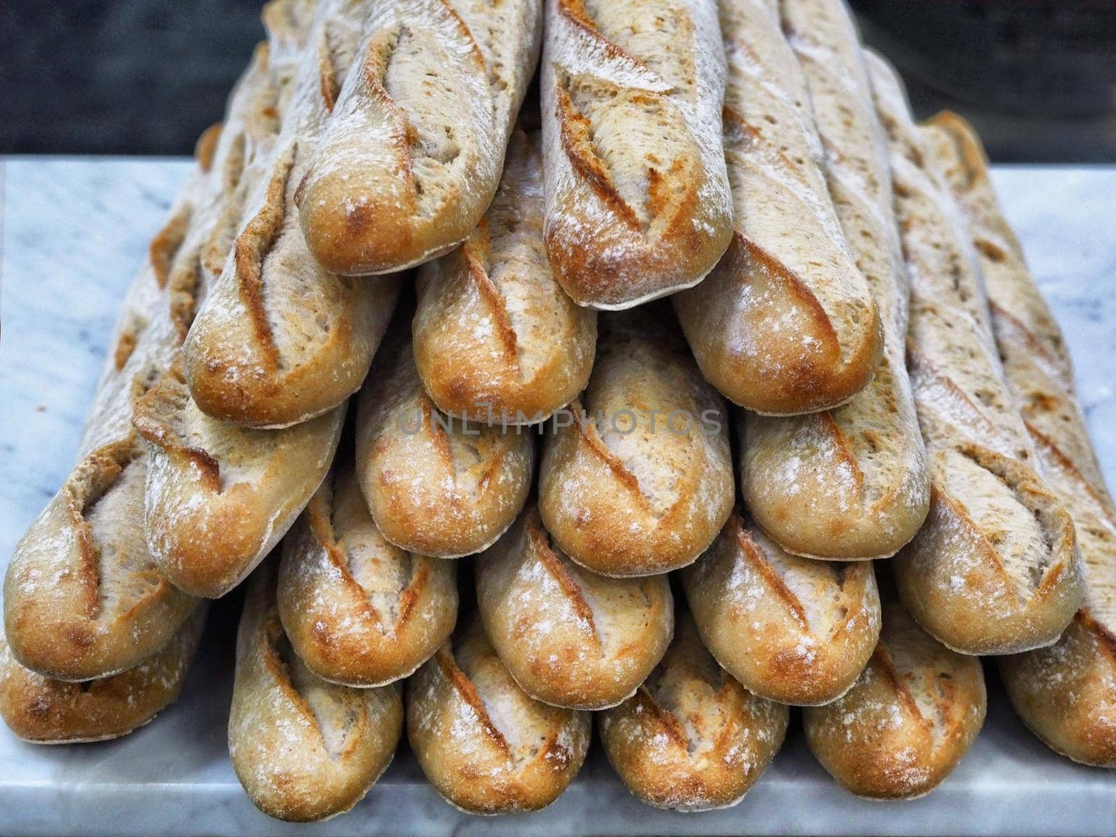Freshly baked bread loaves stacked typical french baguette close up view by lemar