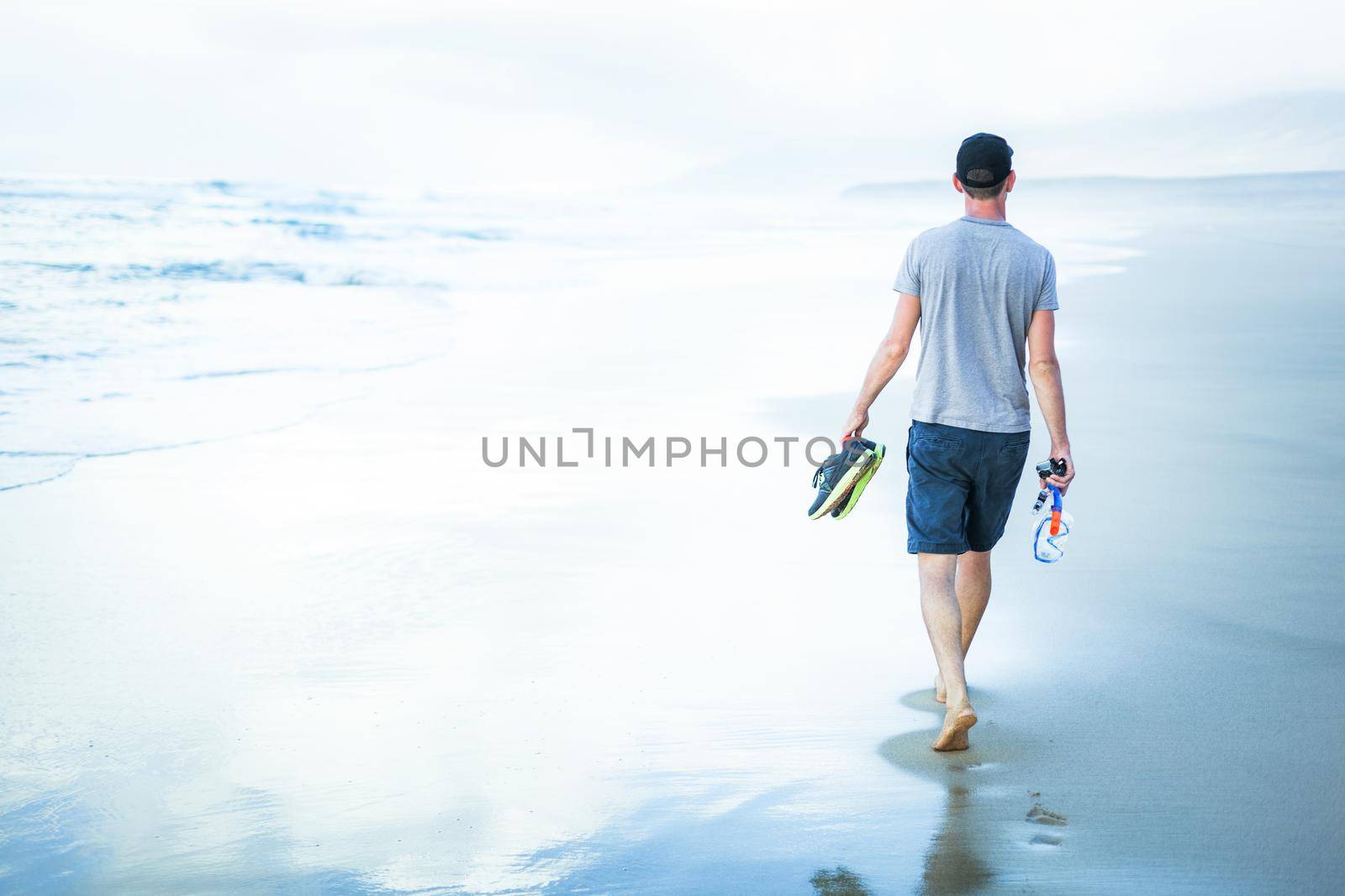 young man walking at sea shore alone and relaxed