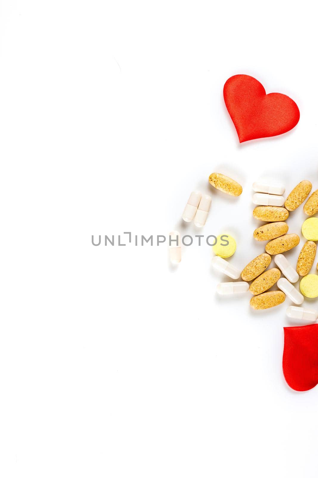 The hearts, tablets and pills isolated on white background Valentines Day or pharmaceutical background