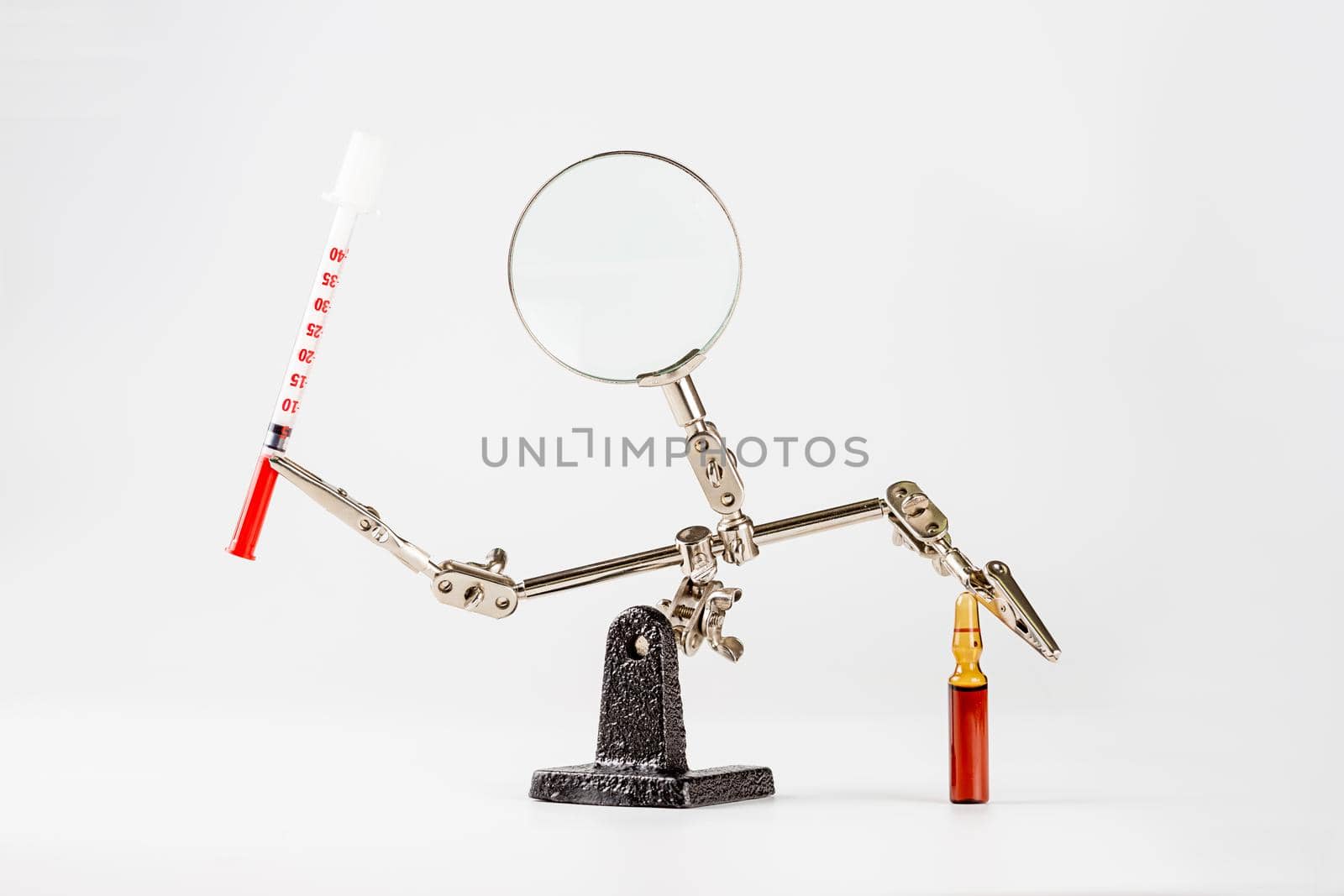 Abstract pharmaceutical background with engineering tool third hand holding ampoule and syringe isolated on white background