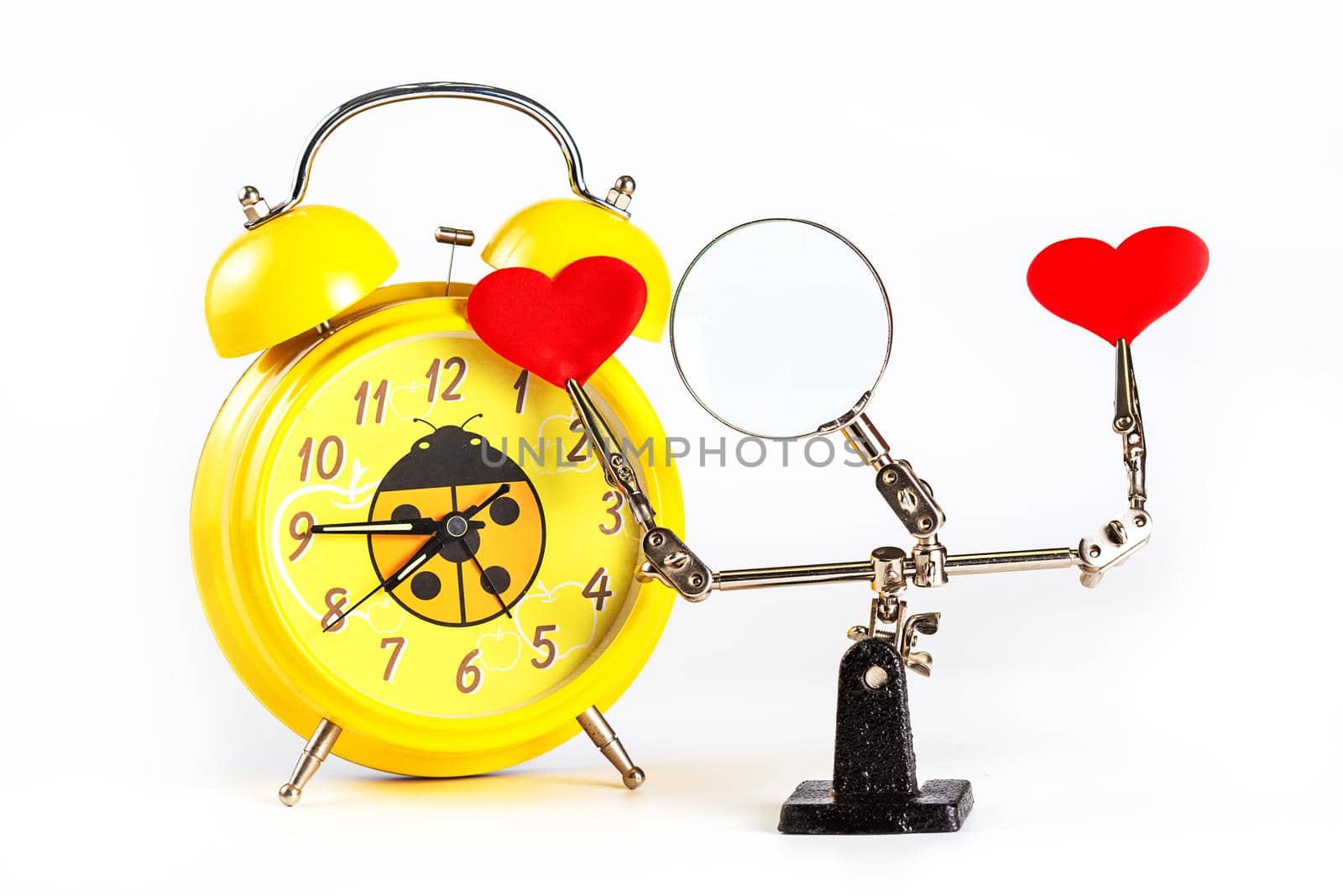 .Abstract Valentines Day background with engineering tool third hand holding hearts and alarm clock on white background