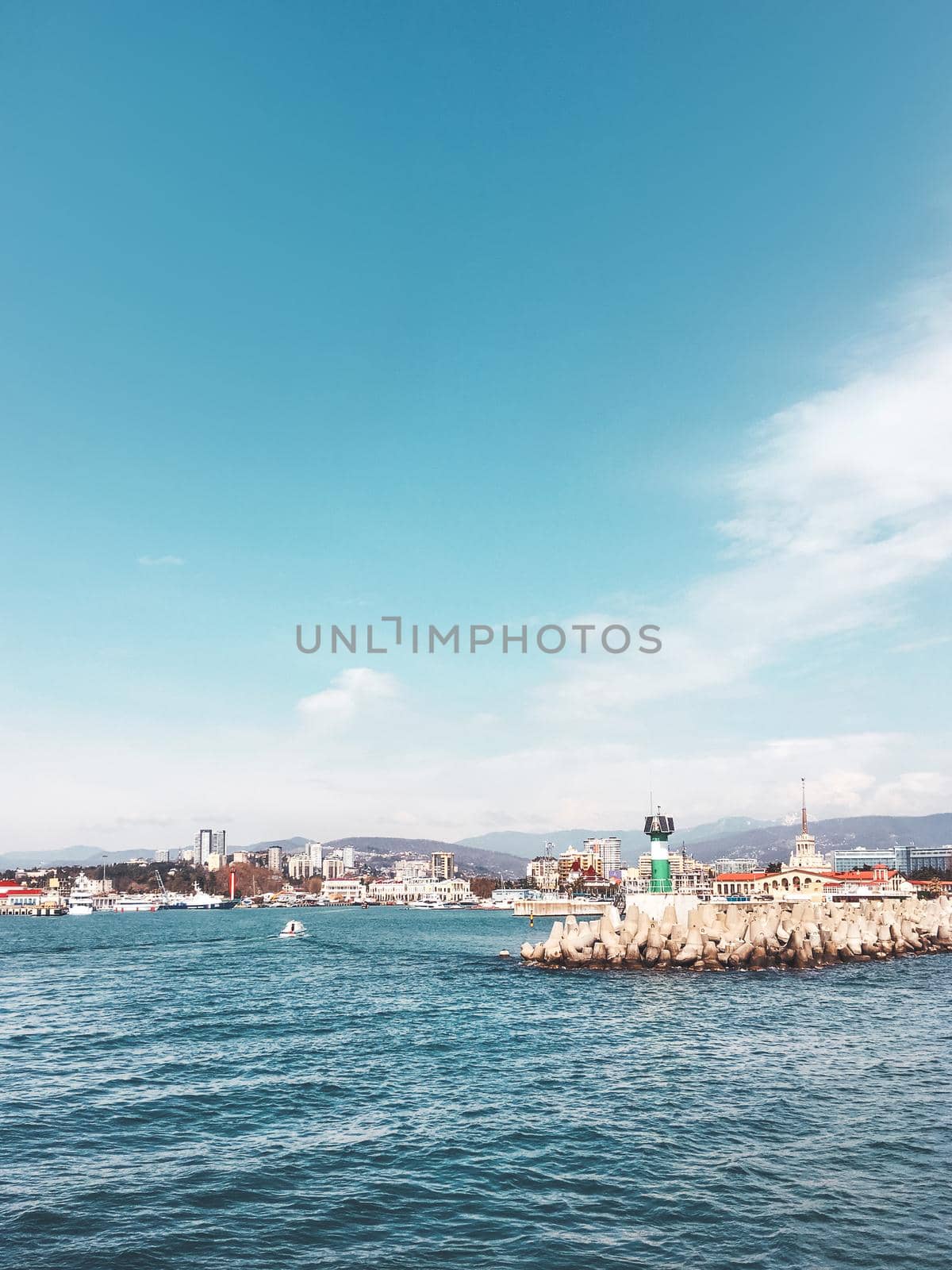 SOCHI, RUSSIA - March 24, 2020. View on port, embankment and lighthouse from Black sea in sunny weather. by aksenovko