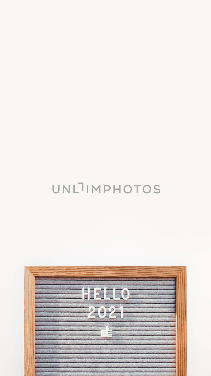 Letter board with words HELLO 2021 and appreciation gesture. New Year promises and resolutions. Copy space on white background. Vertical banner 9:16. by aksenovko