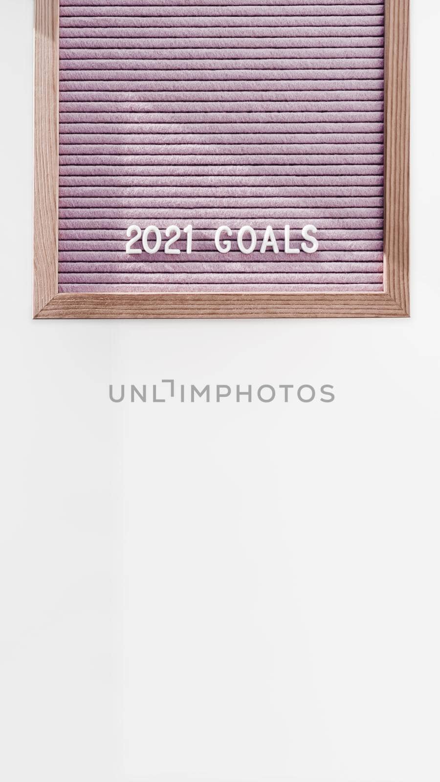 Light pink letter board with words 2021 GOALS. New Year promises and resolutions. Copy space on white background.