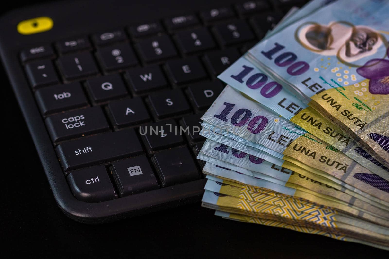 Lei banknotes on keyboard. Selective focus on stack of LEI romanian money.