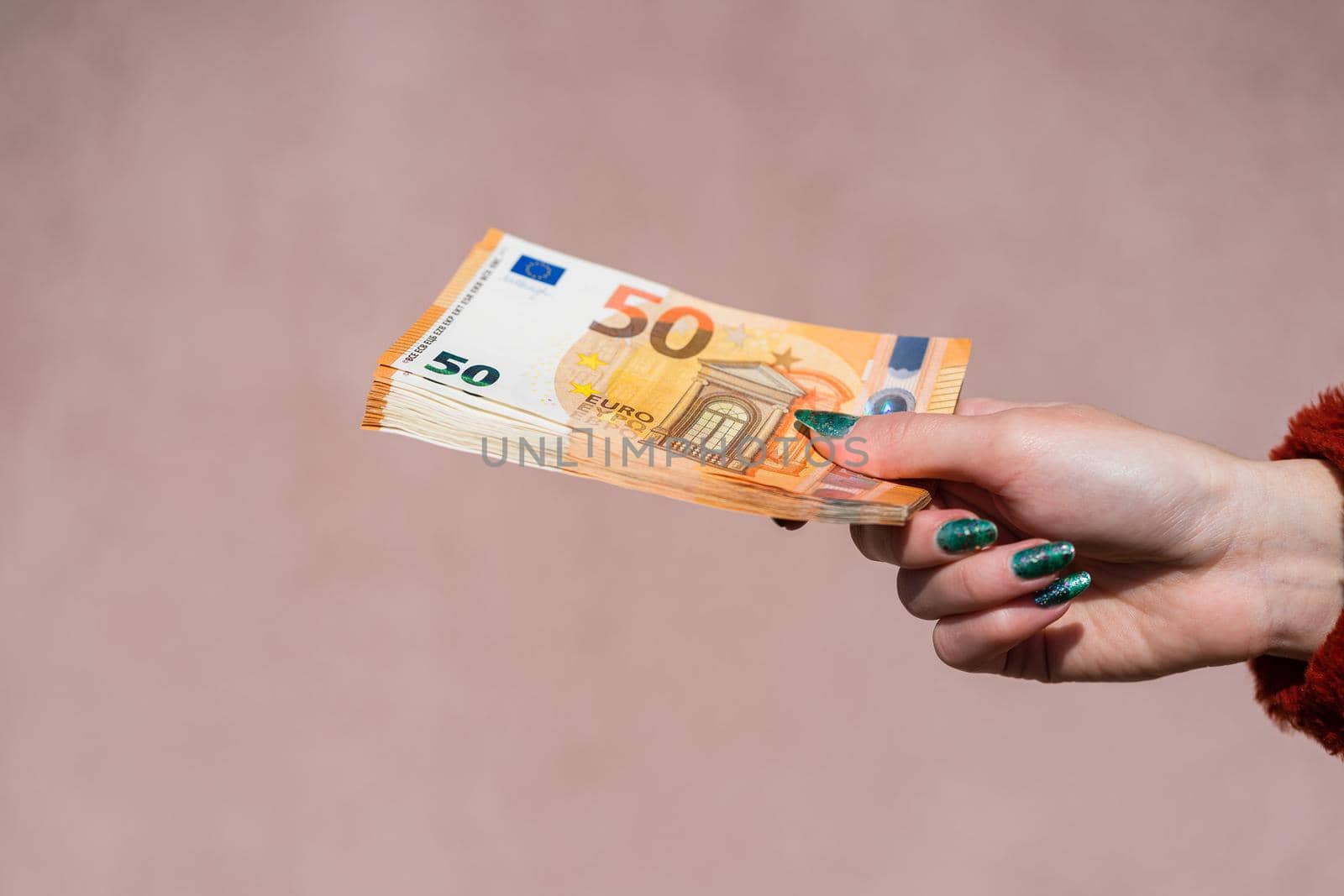 Hand holding showing euro money and giving or receiving money like tips, salary. 50 EURO banknotes EUR currency isolated. Concept of rich business people, saving or spending money.