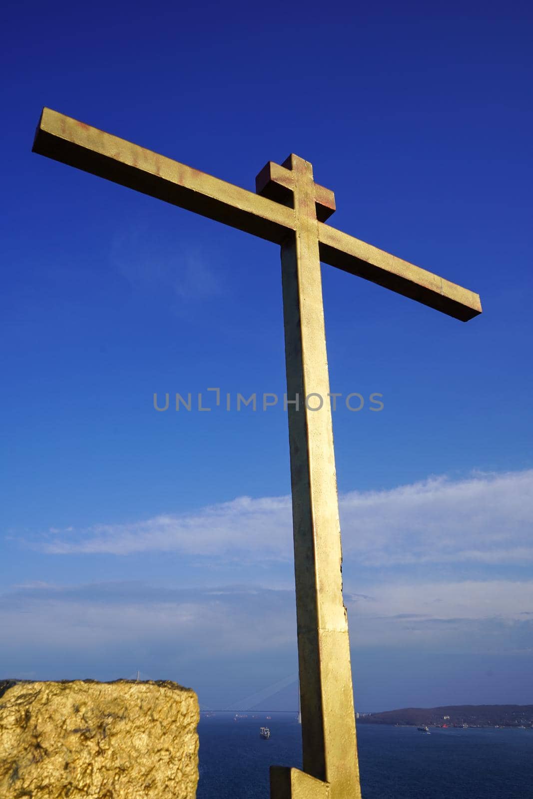 A Golden cross against a blue sky. Vladivostok, Russia.