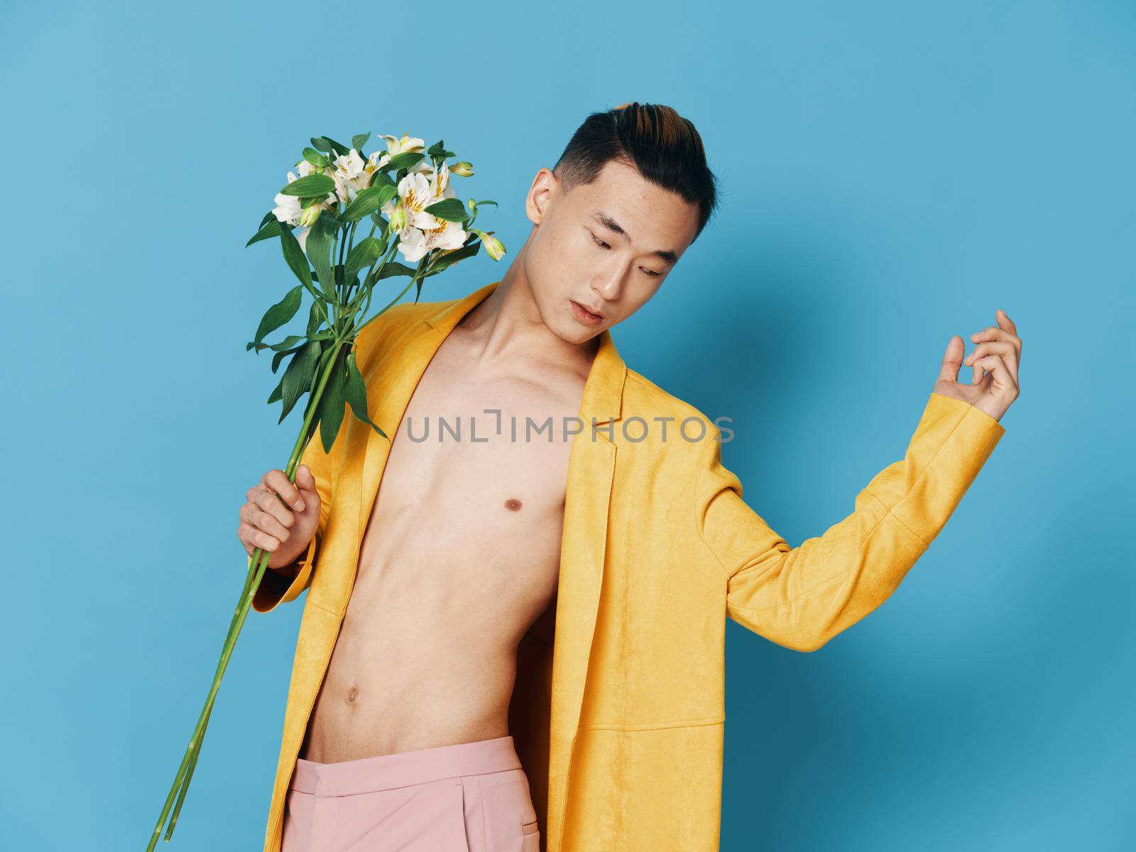 korean man with bouquet of flowers in yellow coat gesturing with hands cropped view by SHOTPRIME