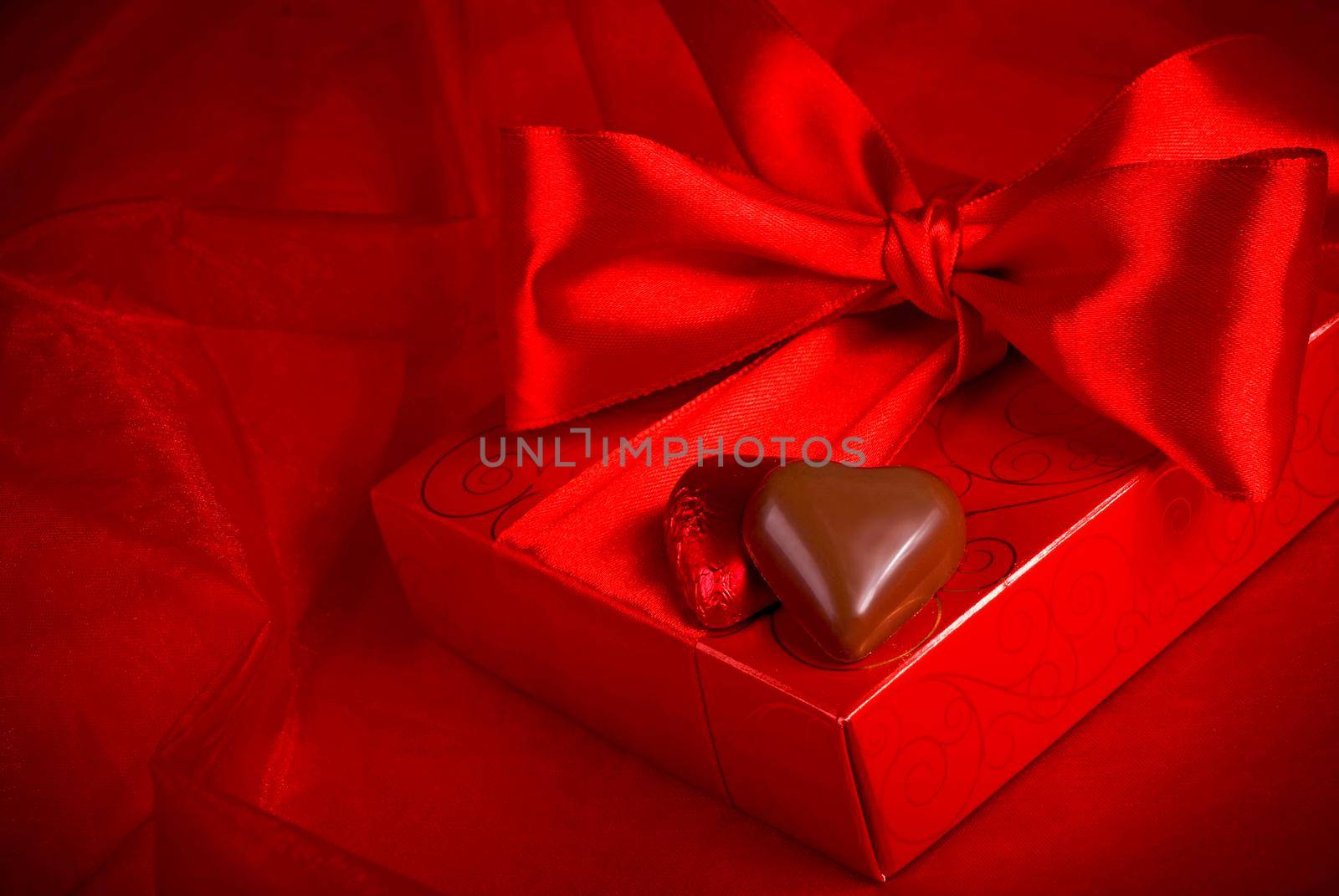 Valentine's Day. Gift candy in the form of a heart on a red background by aprilphoto