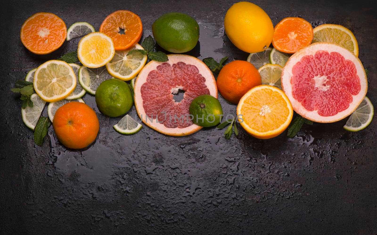 Citrus background. Fresh citrus fruits - Lemons, oranges, limes, grapefruits on wooden background. by aprilphoto