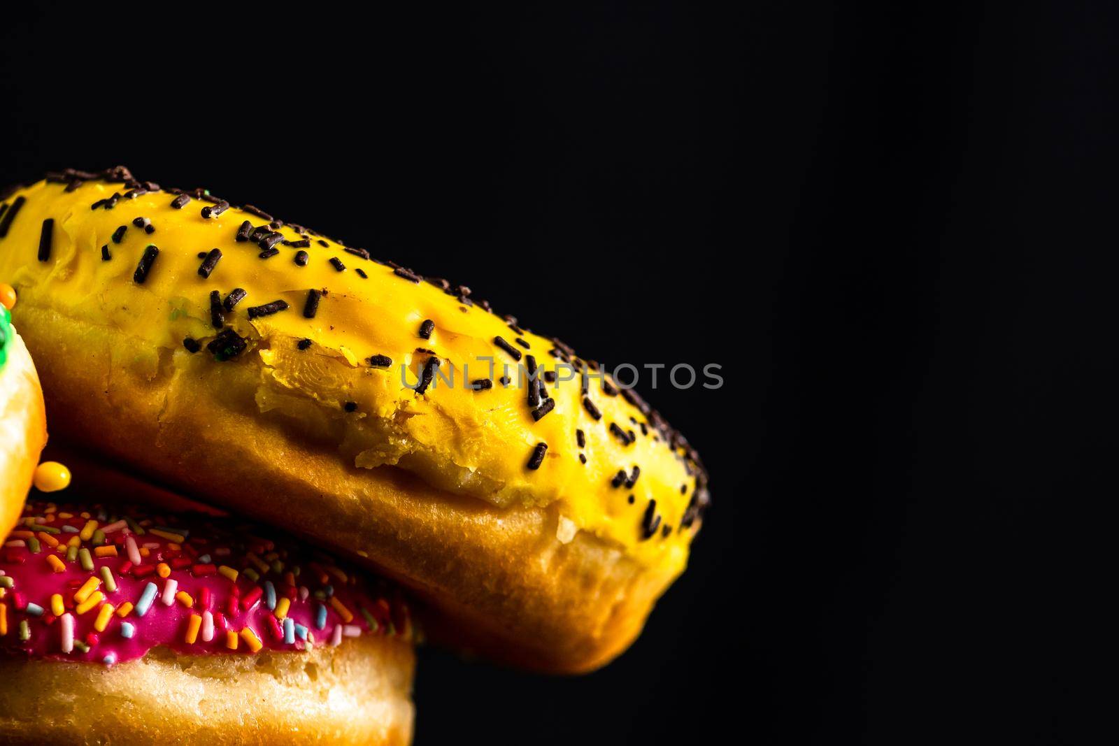 Glazed donuts with sprinkles isolated. Close up of colorful donuts.