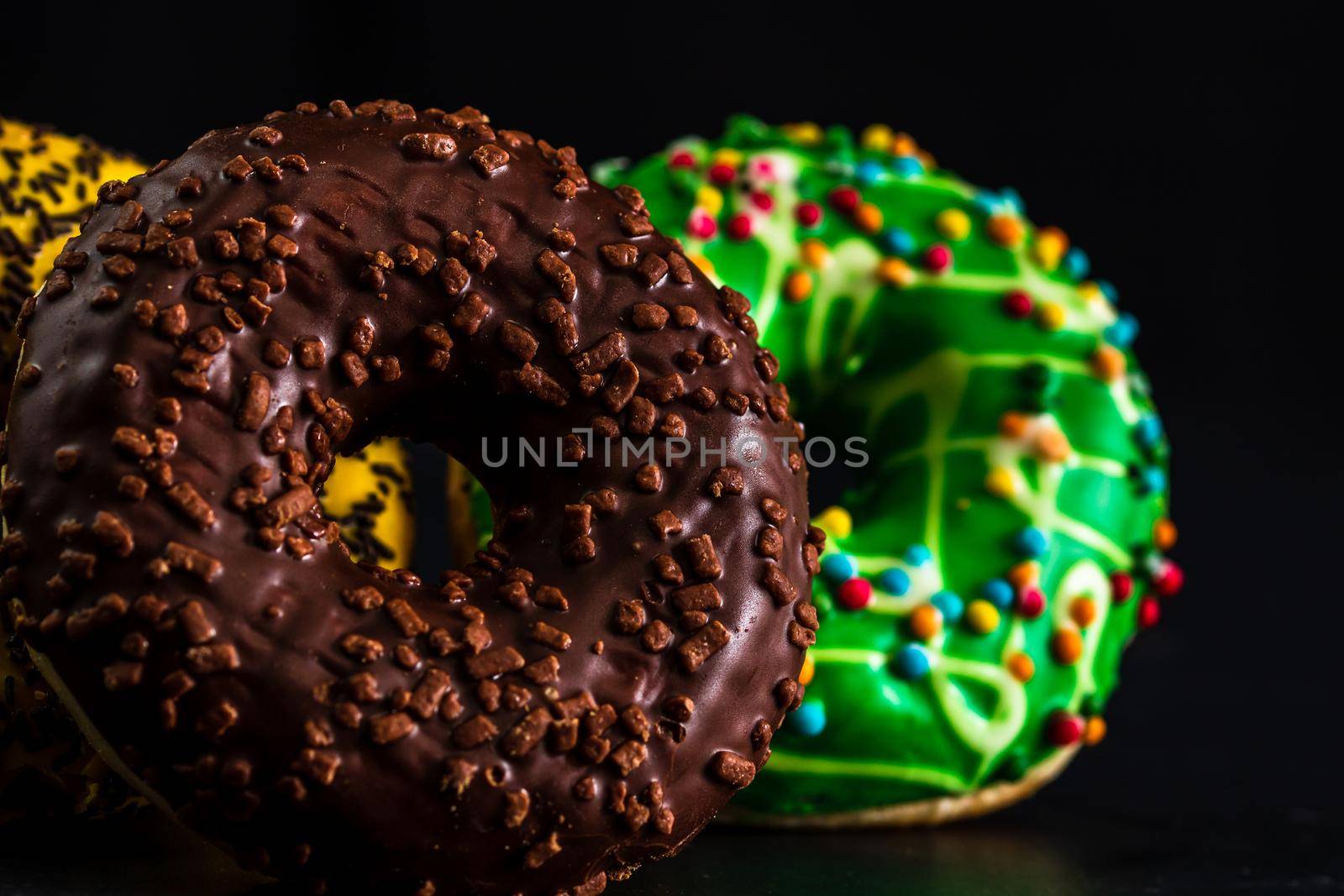 Glazed donuts with sprinkles isolated. Close up of colorful donuts.