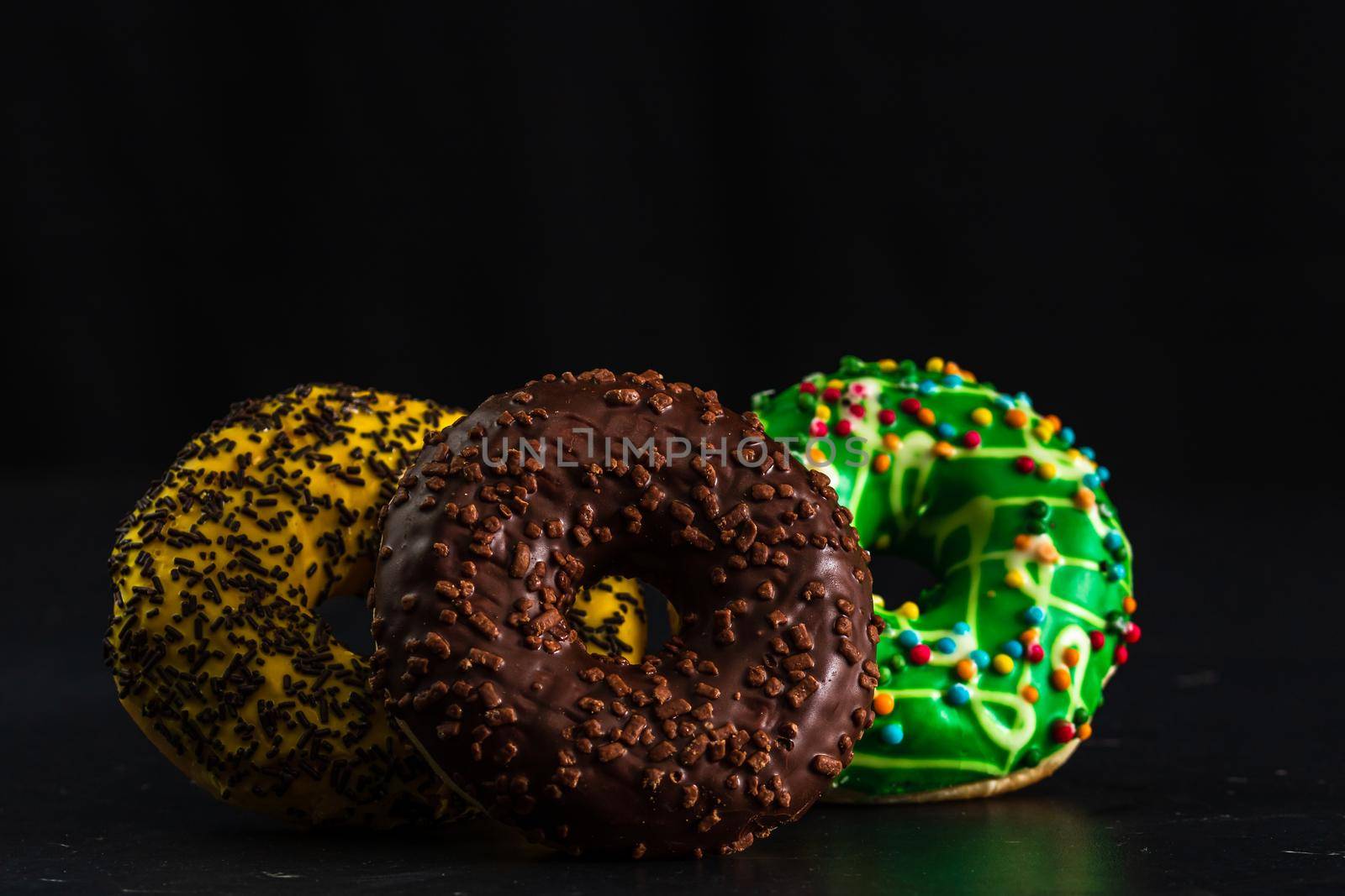  Glazed donuts with sprinkles isolated. Close up of colorful donuts. by vladispas