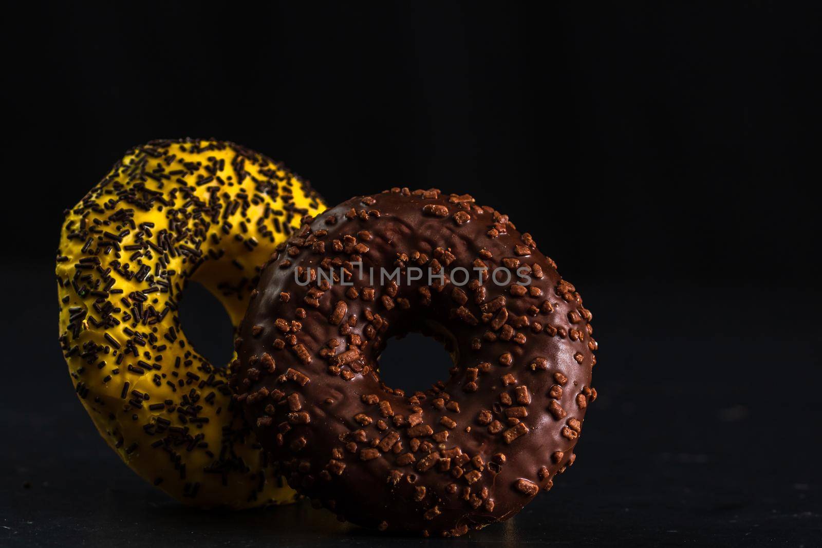 Glazed donuts with sprinkles isolated. Close up of colorful donuts.