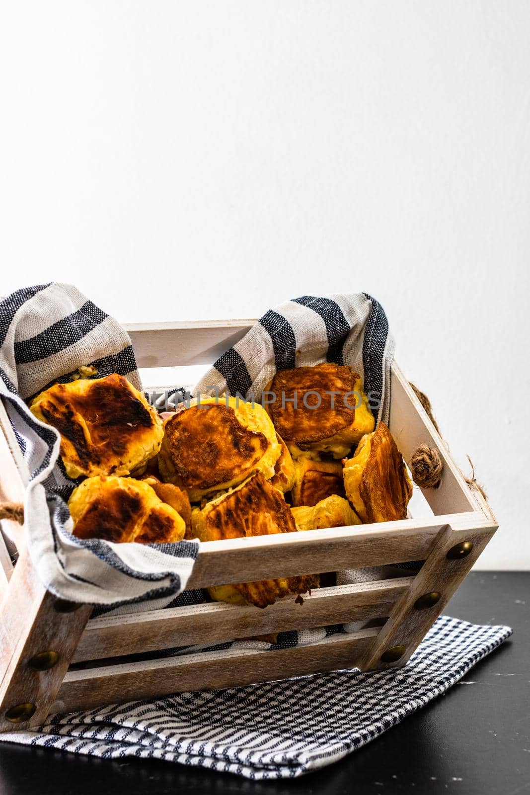 Freshly baked homemade ham and cheese puff pastry in a rustic crate.