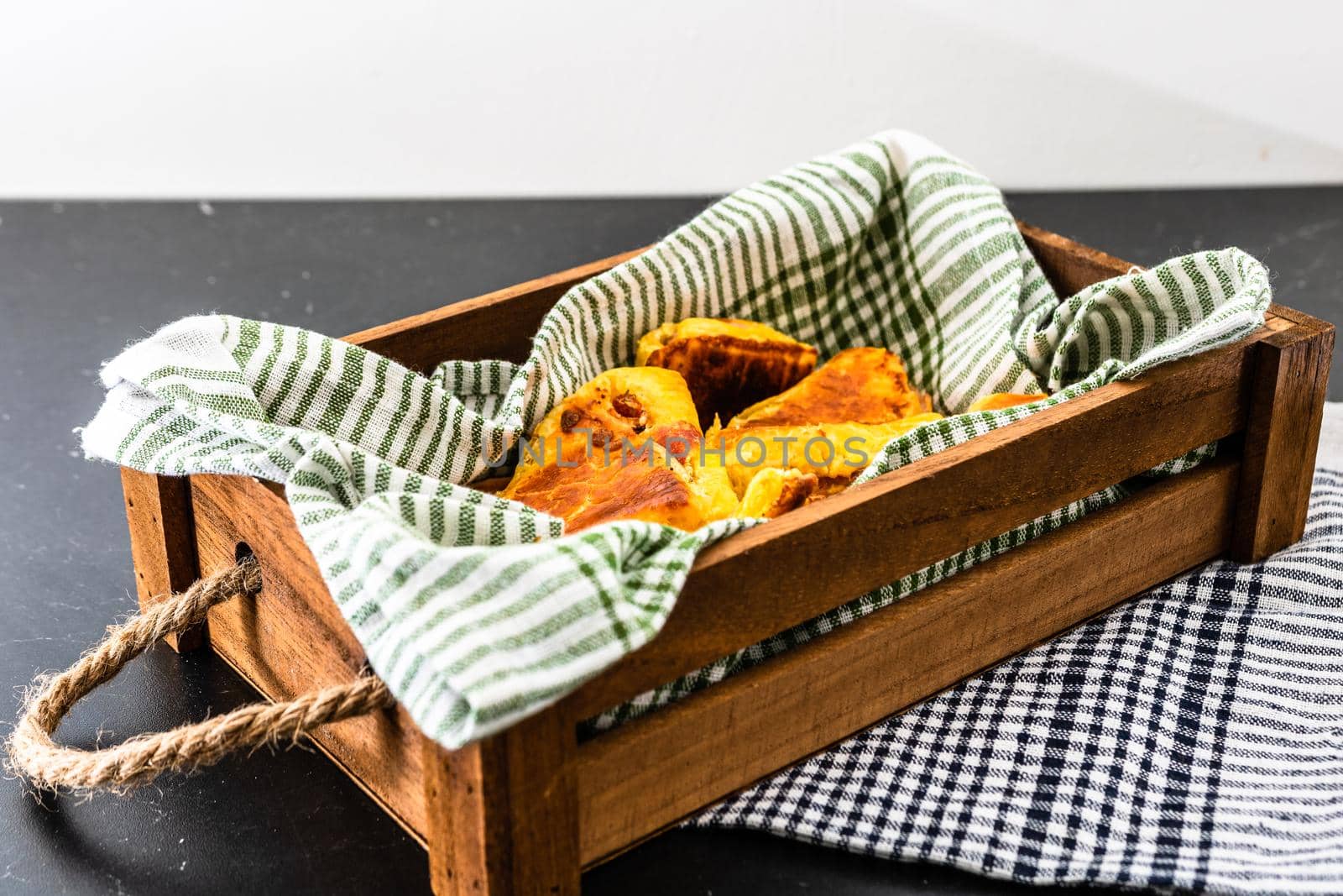 Freshly baked homemade ham and cheese puff pastry in a rustic crate.