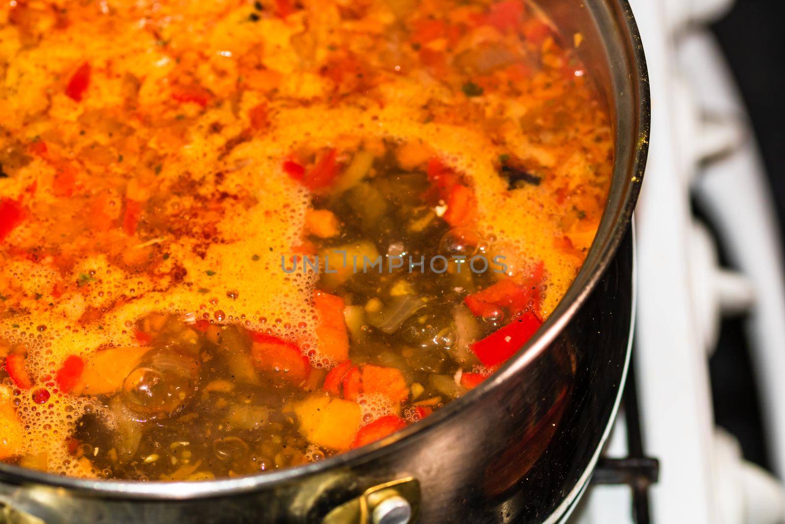 Preparation of soup with chicken and vegetables. Close up of boiling soup.