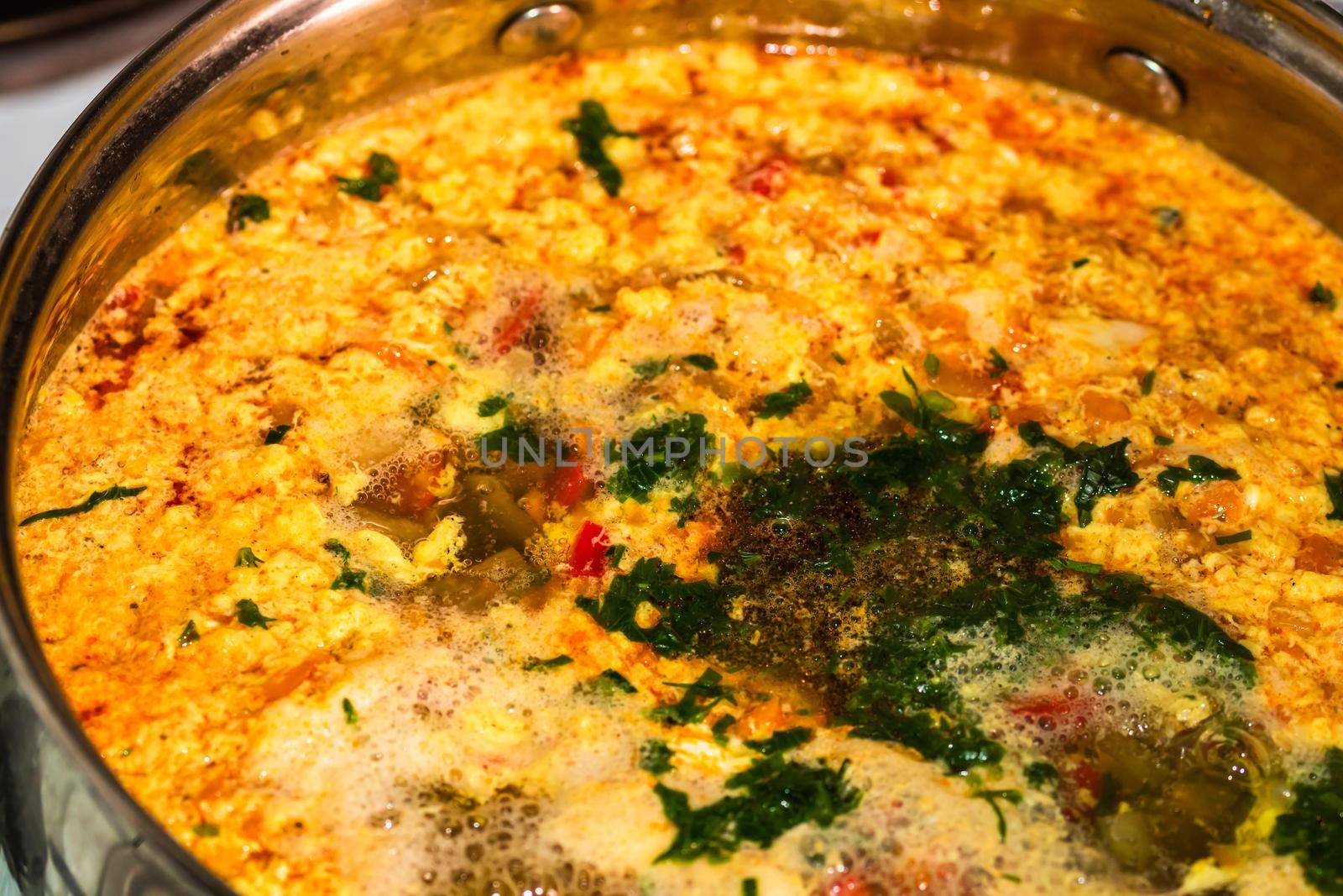 Preparation of soup with chicken and vegetables. Close up of boiling soup.