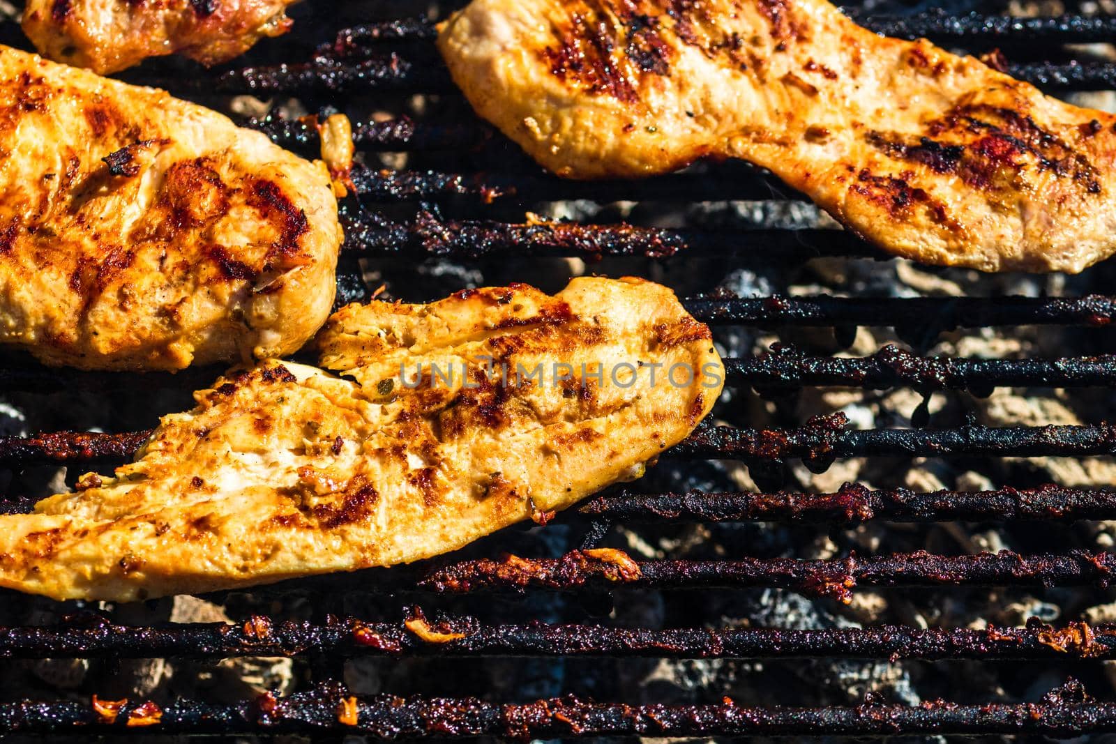 Chicken and pork steak grilled on a charcoal barbeque. Top view of camping tasty barbecue, food concept, food on grill and detail of food on the grill by vladispas