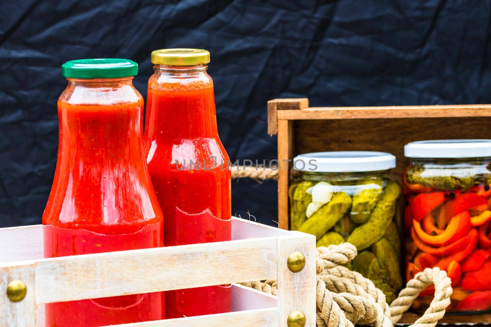 Bottles of tomato sauce, preserved canned pickled food concept isolated in a rustic composition.