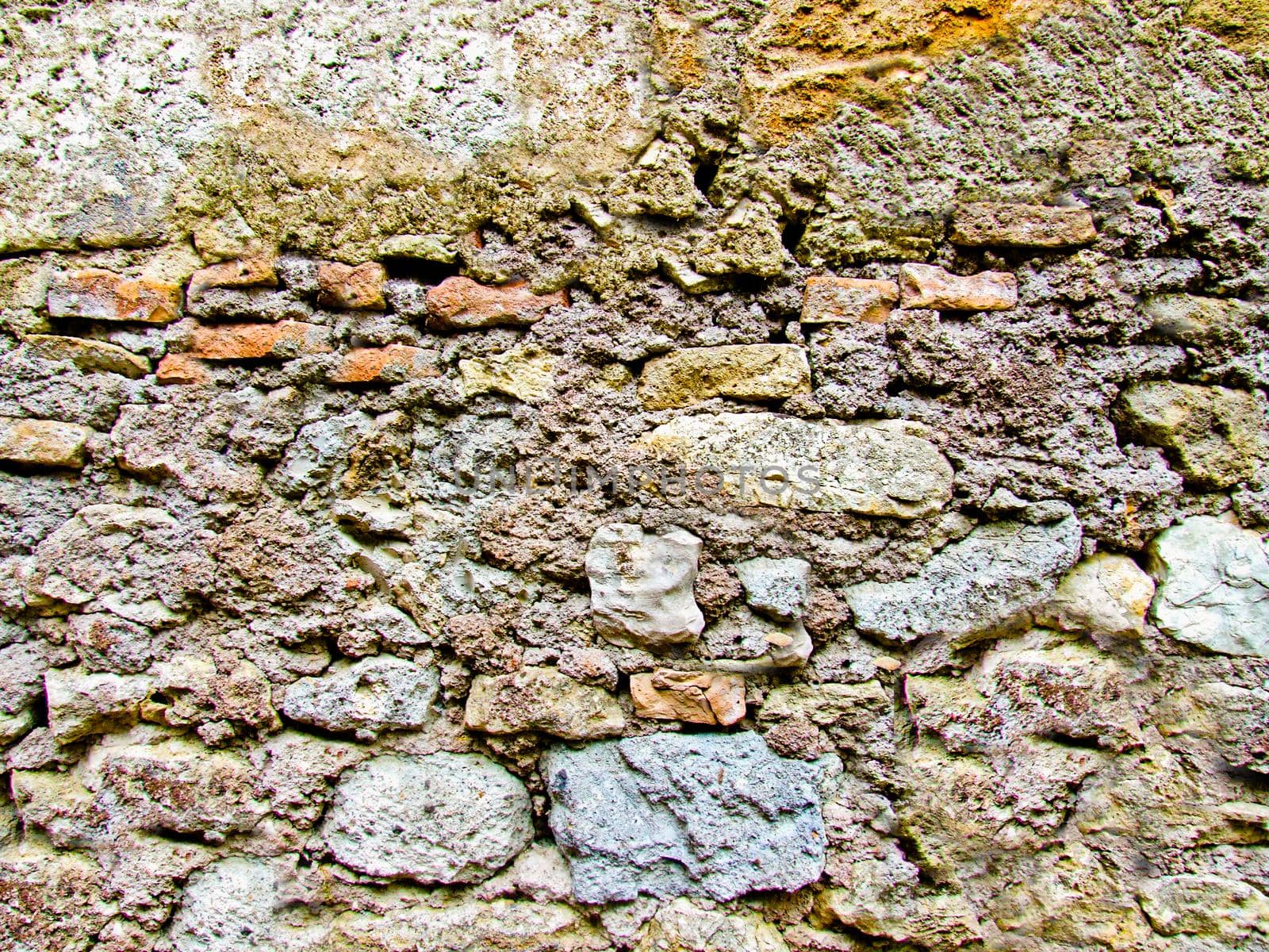 Antique stone wall of gray color with yellow moss and mold.Texture or background