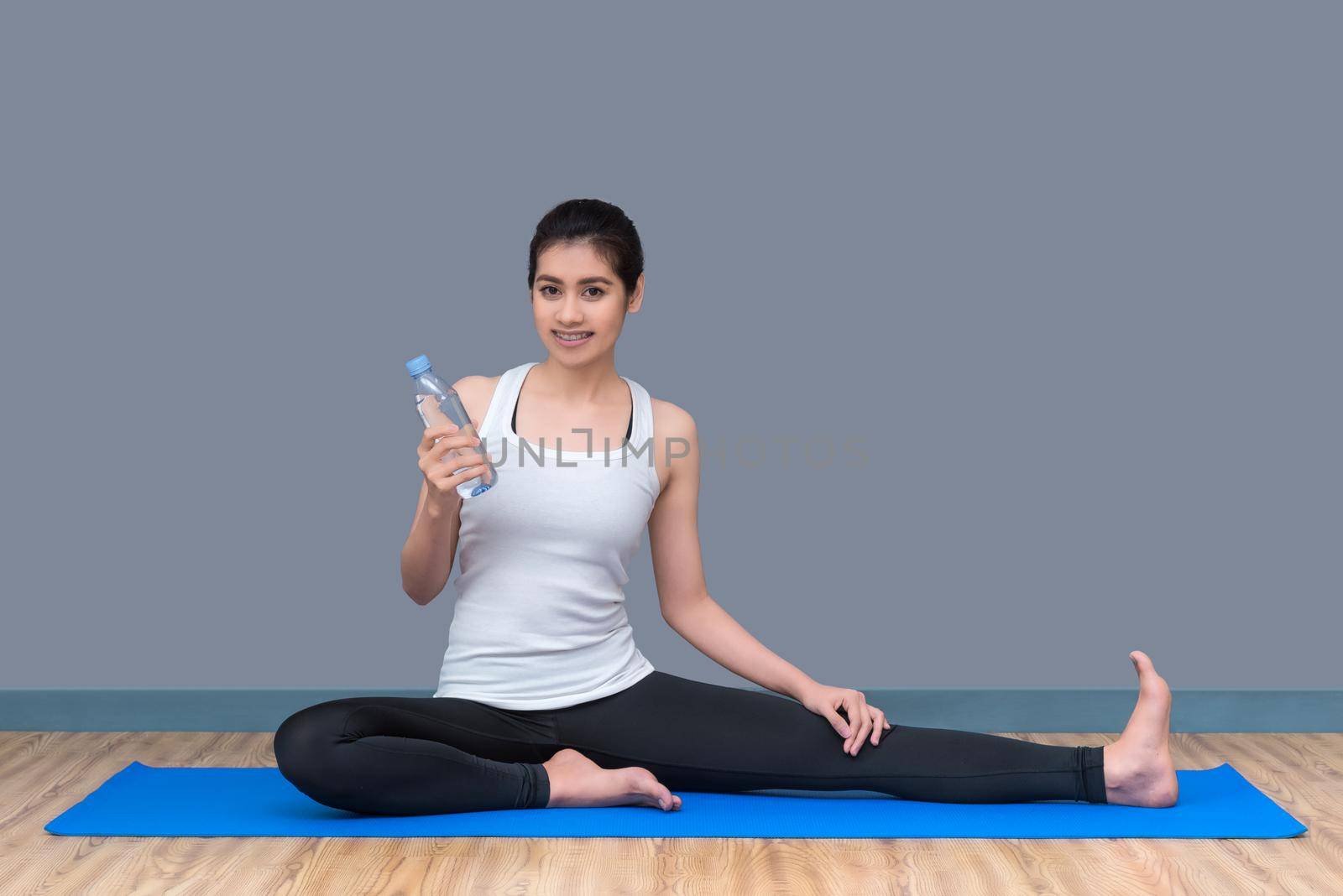 Young asian woman drink water after finish workout at healthy sport gym.Photo concept for Yoga Sport and Healthy lifestyle