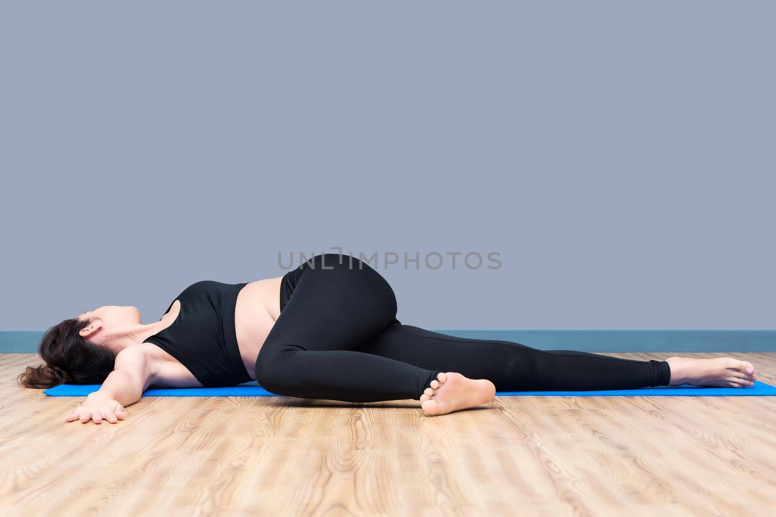 Healthy woman exercising yoga at sport gym, girl doing sport indoor.Photo design for fitness sporty woman and healthcare concept.