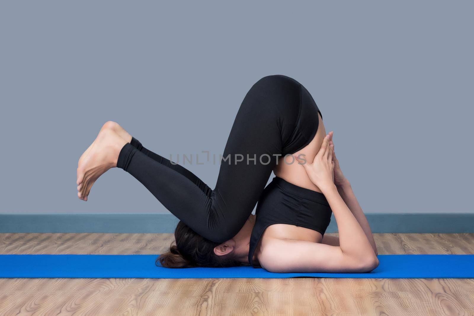 Asian healthy woman exercising yoga at sport gym, girl doing sport indoor.Photo design for fitness sporty woman and health care concept.