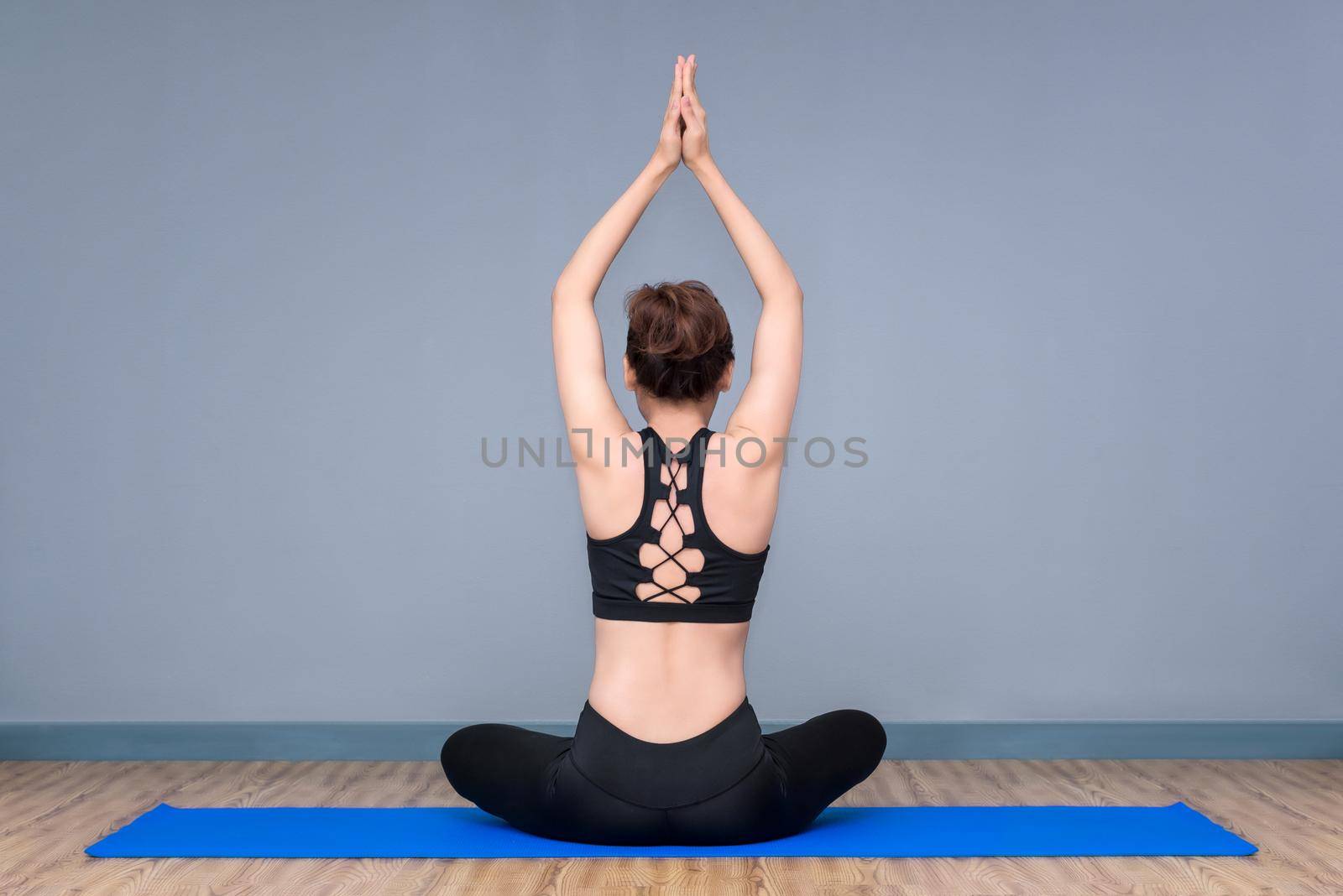 Healthy woman exercising yoga at sport gym, girl doing sport indoor.Photo design for fitness sporty woman and healthcare concept. by Nuamfolio
